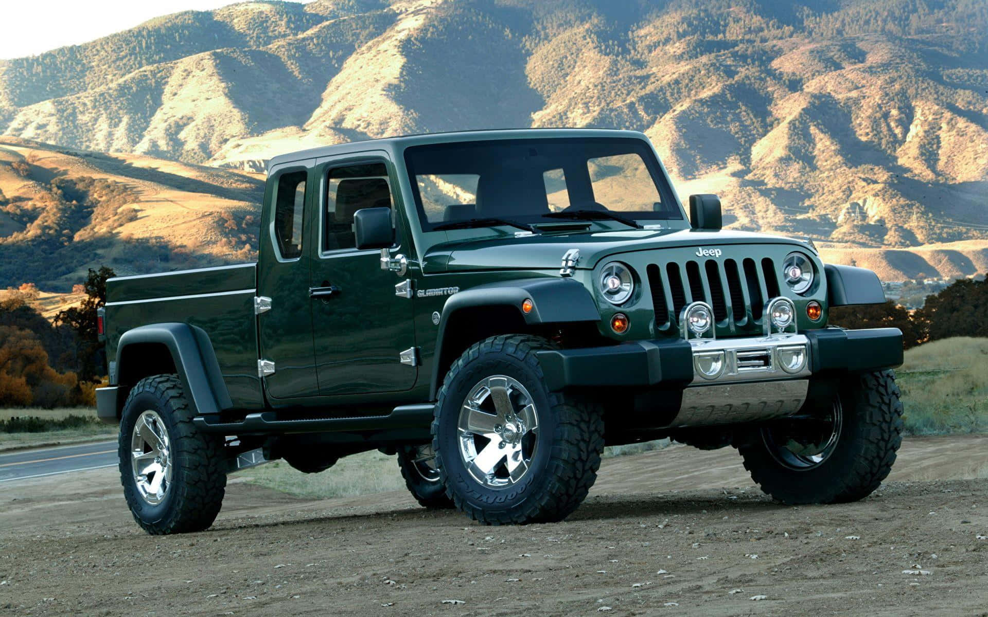 Jeep Gladiator 桌布 壁紙 — 一輛堅固的綠色Jeep Gladiator pickup貨車停泊在泥地上，背景是山區地形，在明亮的日光下。