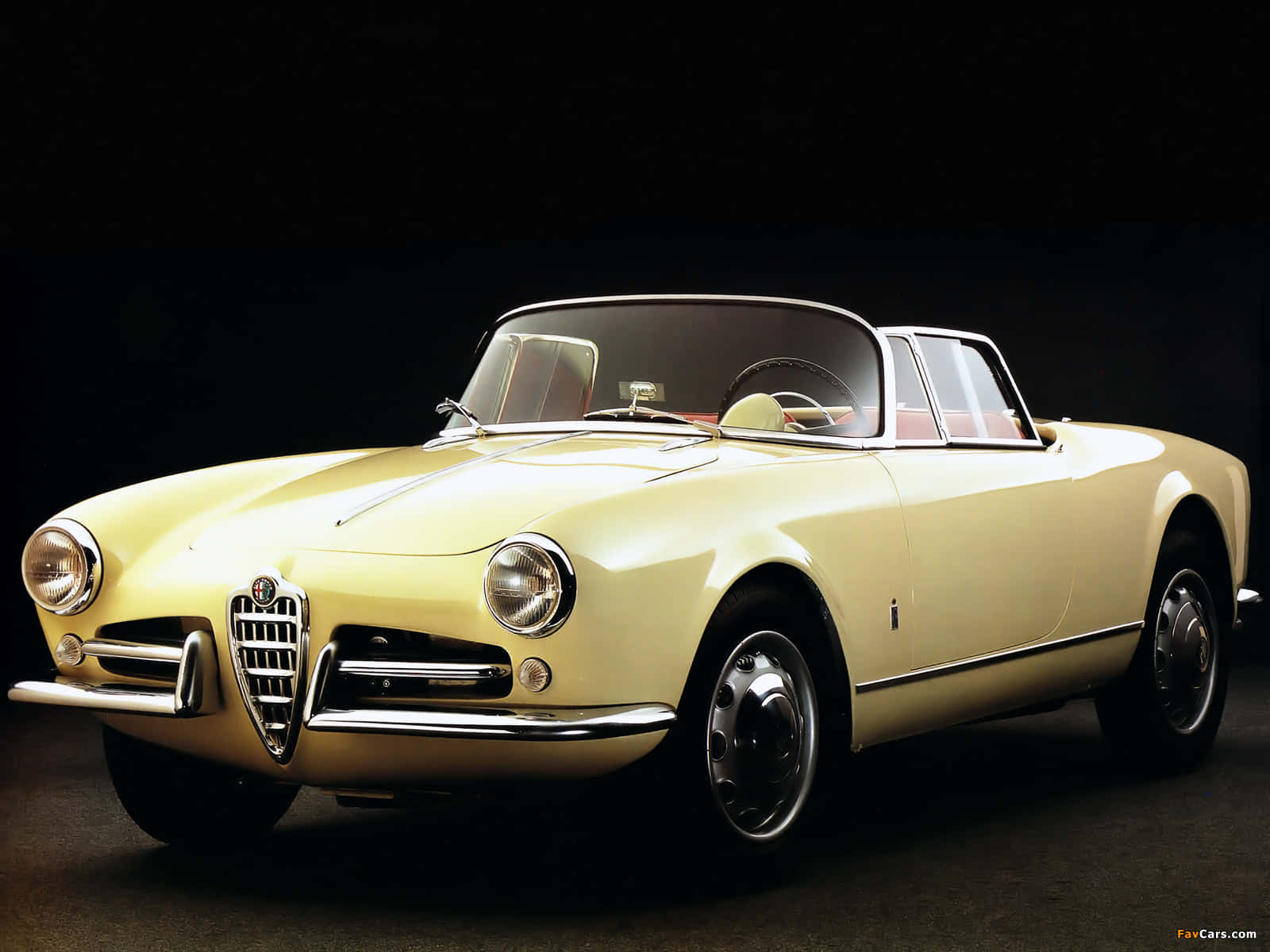 Alfa Romeo Spider 桌布 壁紙 — 一輛奶油黃色的經典愛快羅密歐Spider開篷車在攝影棚燈光下，在純黑背景中閃閃發光。