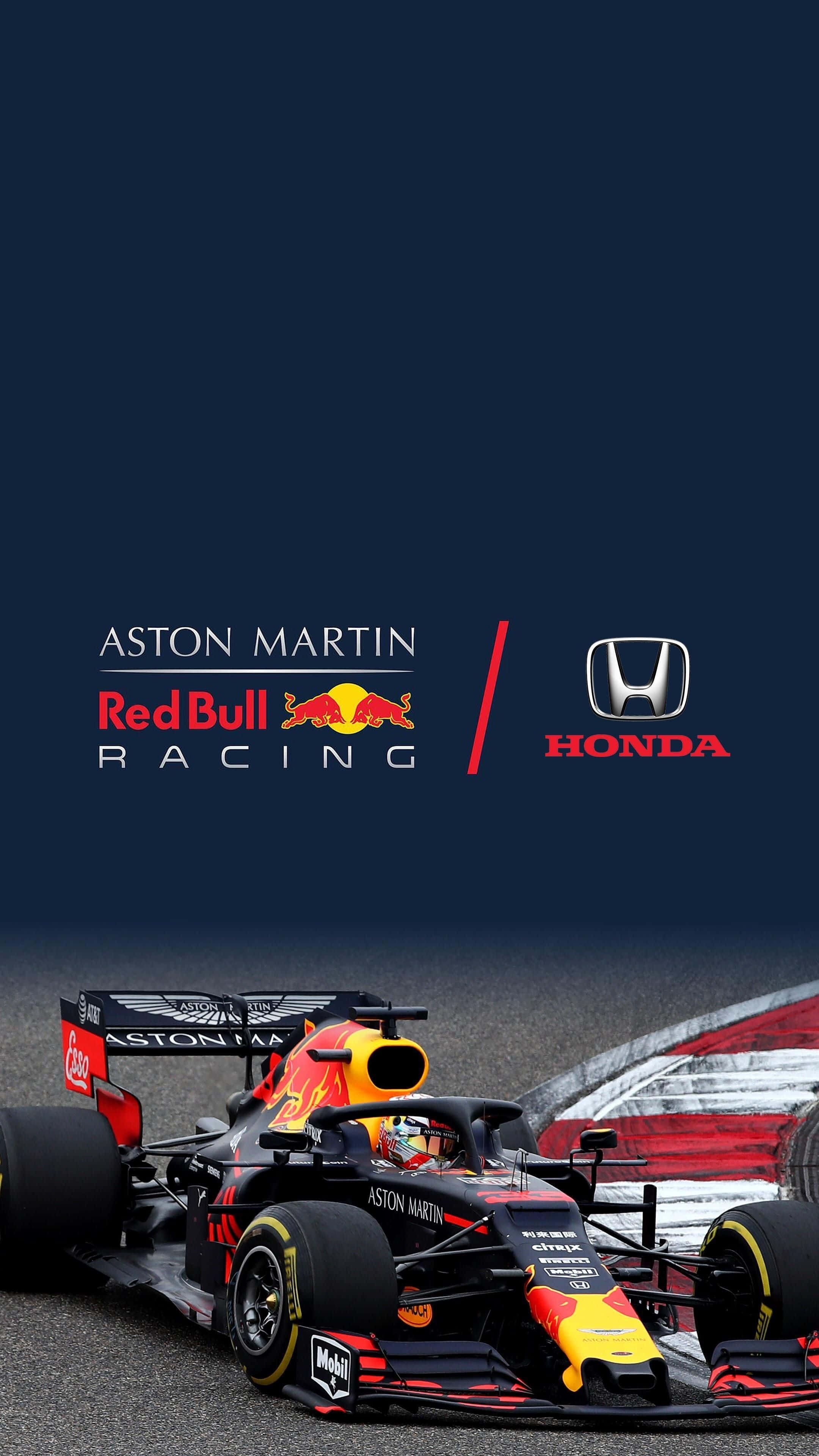 麥斯·韋斯塔本 桌布 壁紙 — 一輛帶有Aston Martin和Honda標誌的Red Bull Racing一級方程式賽車在黑暗天空下的賽道上飛馳。