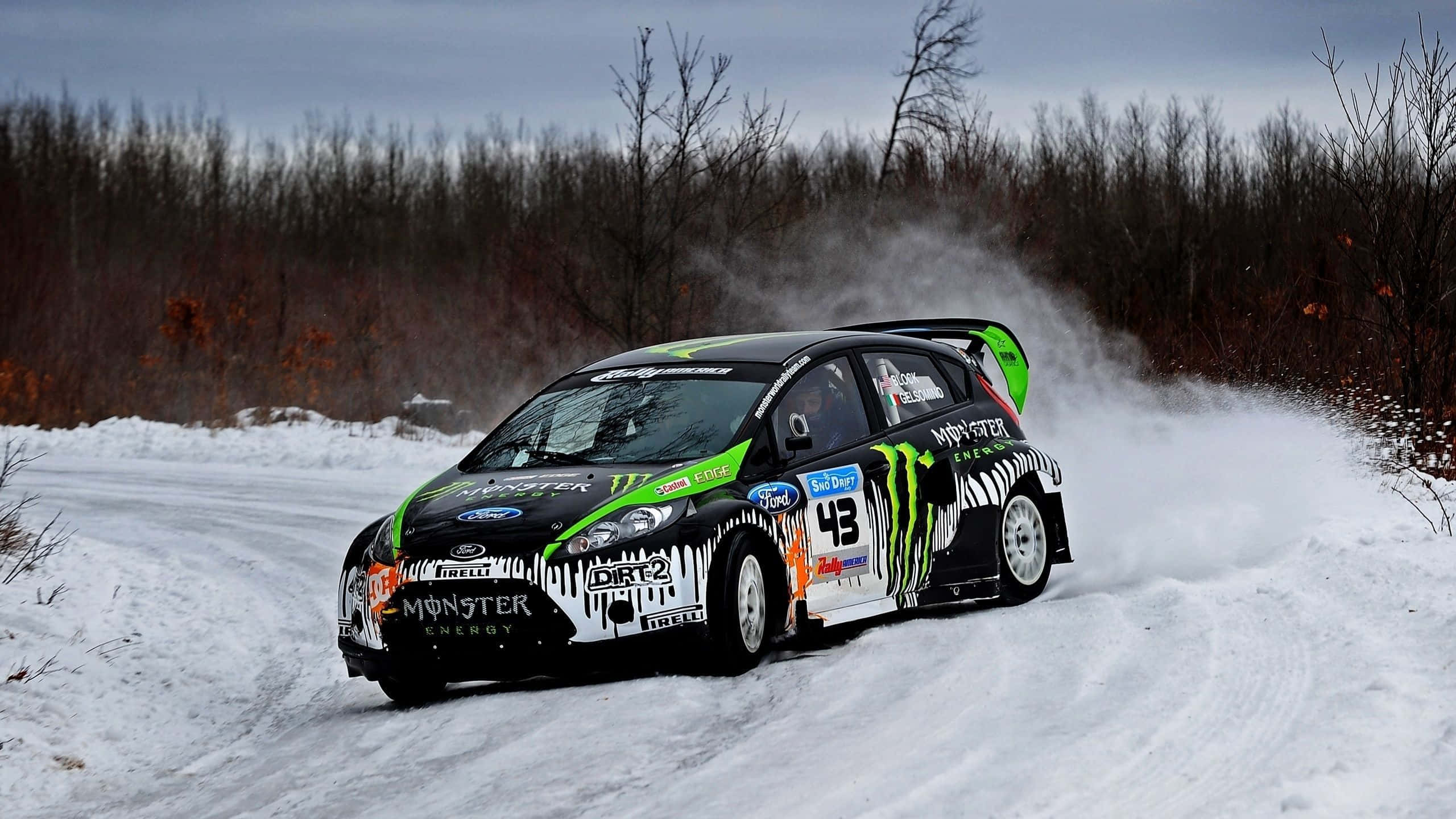 Ice Racing 桌布 壁紙 — 一輛帶有Monster Energy塗裝的黑綠色拉力賽車在冬季森林中飛馳，揚起雪花。