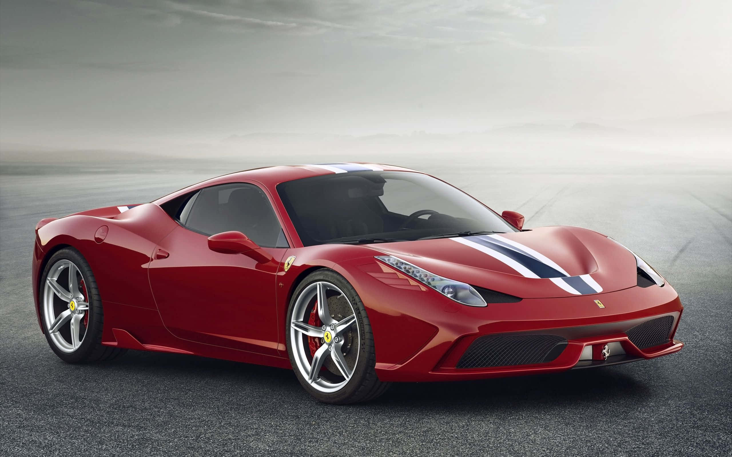 Ferrari 458 Speciale 桌布 壁紙 — 一輛帶有白色賽車條紋的時尚紅色法拉利跑車，在灰色天空下，於霧氣瀰漫的瀝青賽道上滑行。