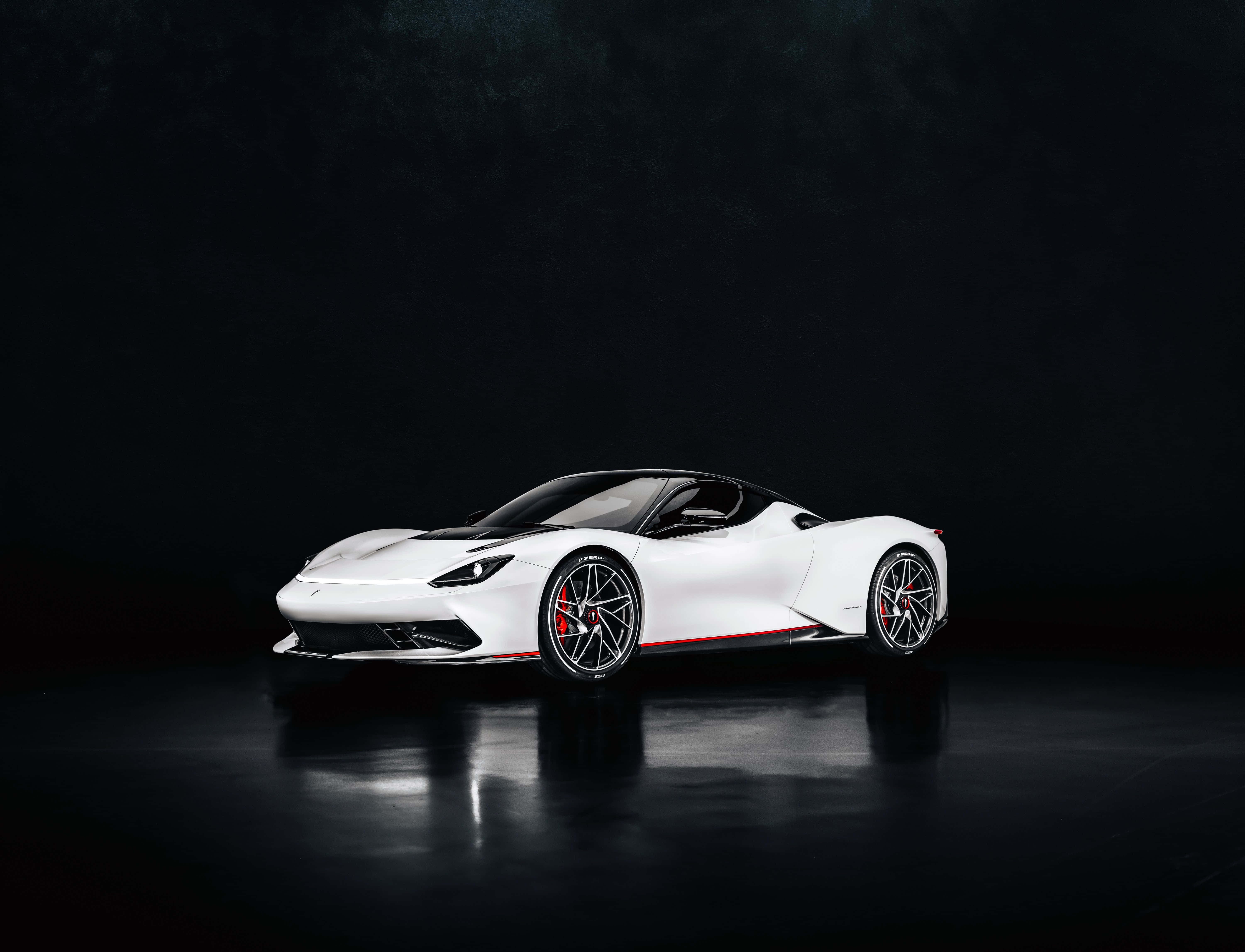 Pininfarina 桌布 壁紙 — 一輛帶有紅色點綴的時尚白色跑車在深色反光地板上於攝影棚燈光下閃閃發光。