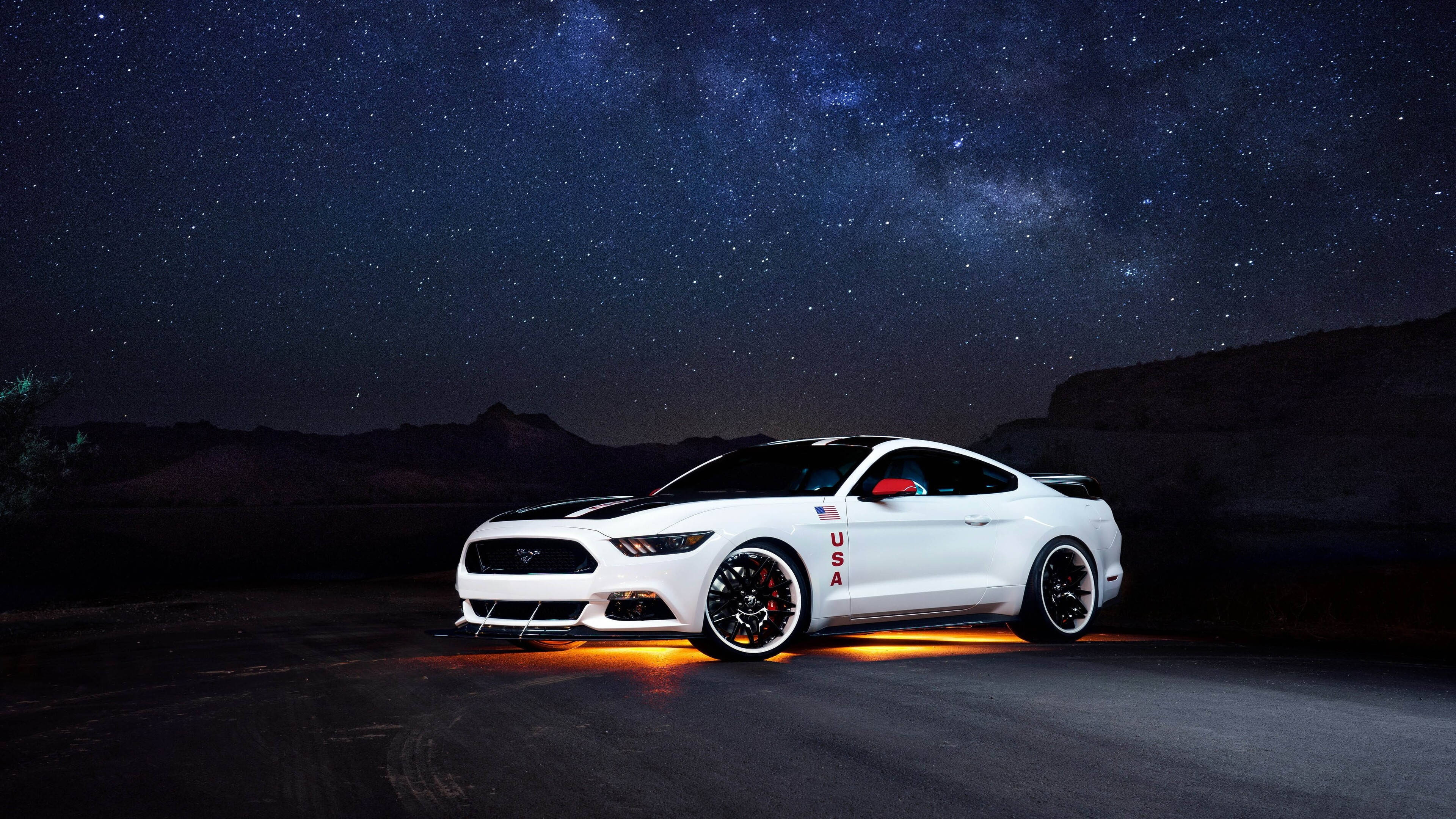 mustang HD 桌布 壁紙 — 一輛帶有美國貼紙的白色野馬在星空下對著沙漠山丘發光。