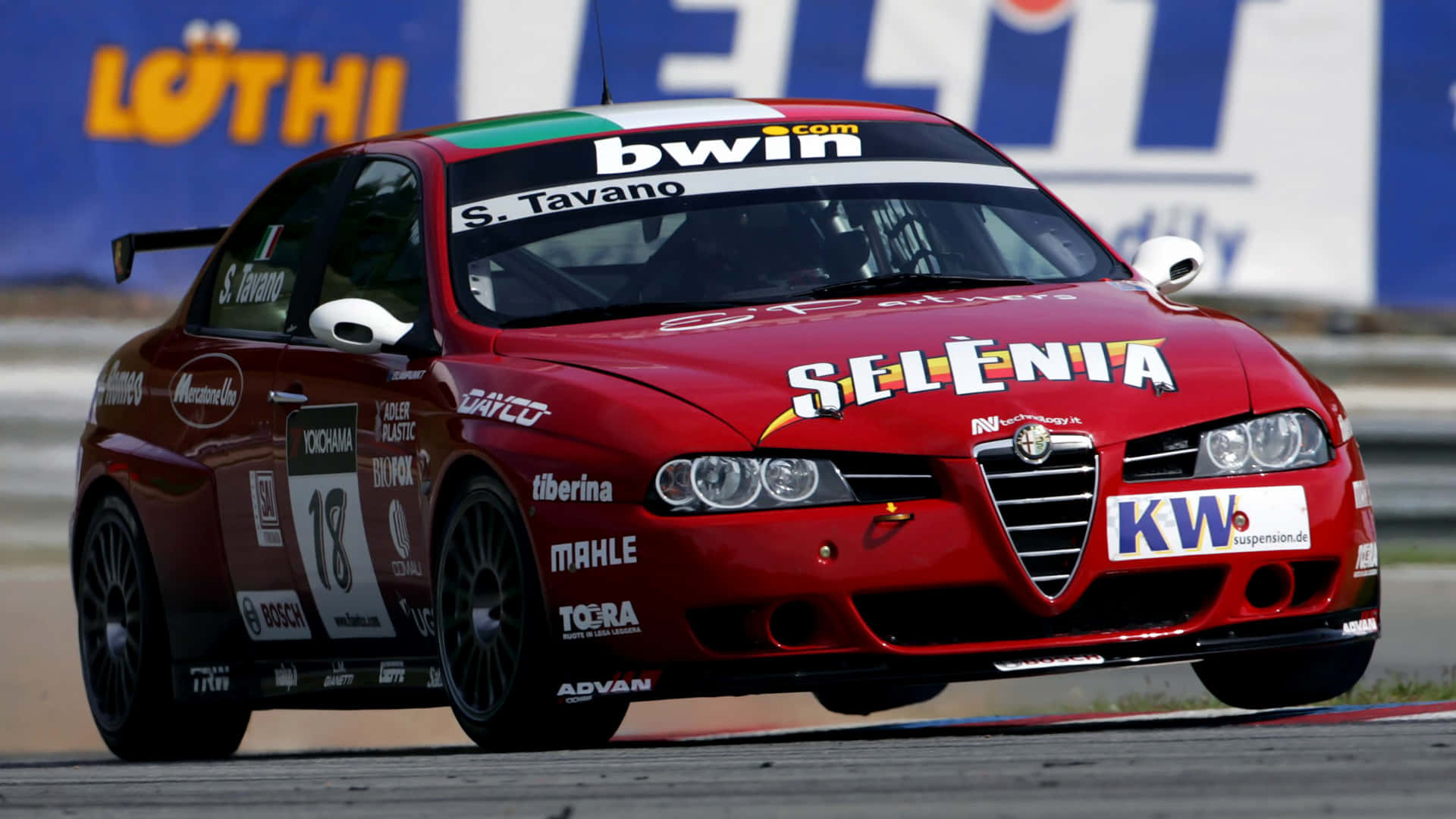 Alfa Romeo 156 桌布 壁紙 — 一輛帶有贊助商貼紙的紅色愛快羅密歐賽車，在明亮的日光下沿著賽道飛馳。