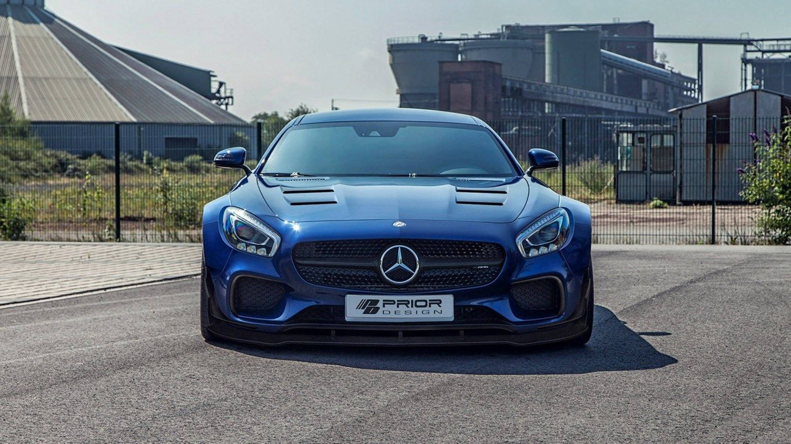 HD 桌布 壁紙 — 一輛引人注目的藍色Mercedes-AMG GT S，帶有Prior Design改裝，停在工業綜合體前的瀝青路面上。