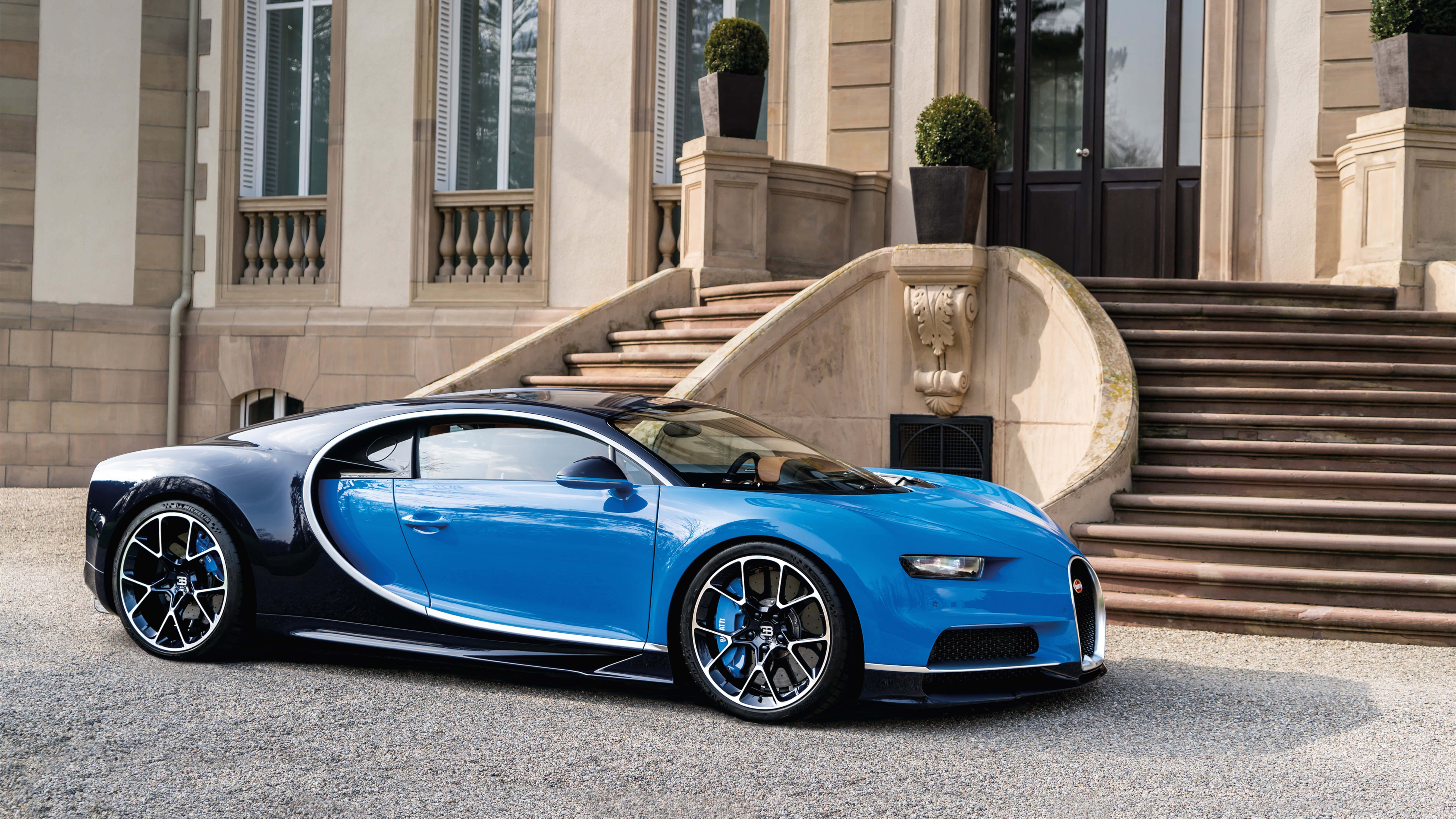 Sports Car 桌布 壁紙 — 一輛引人注目的藍黑色布加迪威龍停在碎石路上，前面是一座帶有華麗階梯的宏偉石砌豪宅。