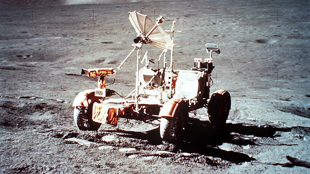 Lunar Rover 桌布 壁紙 — 一輛復古月球車停在灰色月球表面，在明亮的陽光下投下長長的影子。
