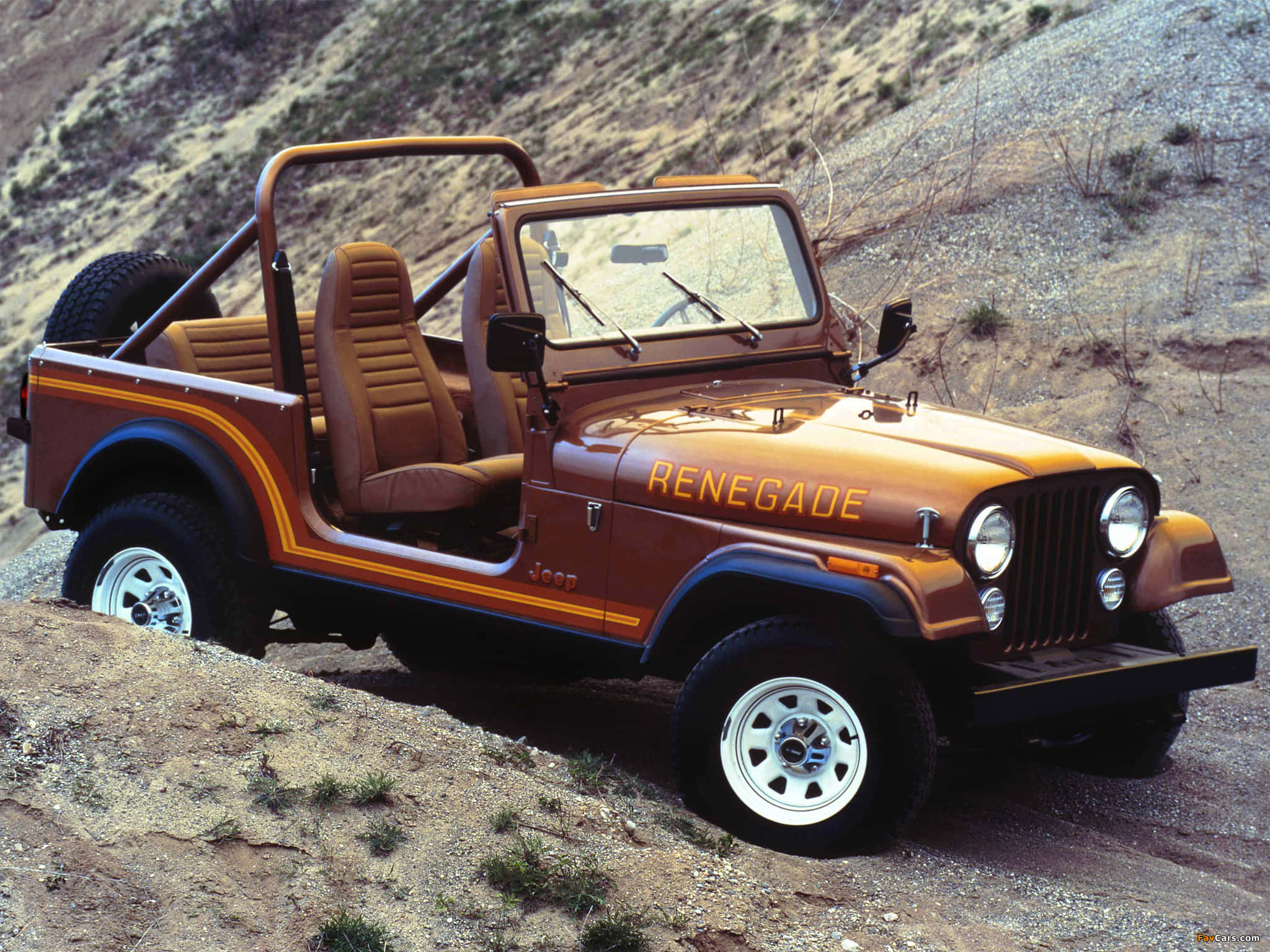 Jeep Cj 桌布 壁紙 — 一輛復古橙色Jeep Renegade，配米色內飾，停在陽光明媚的岩石沙漠斜坡上。