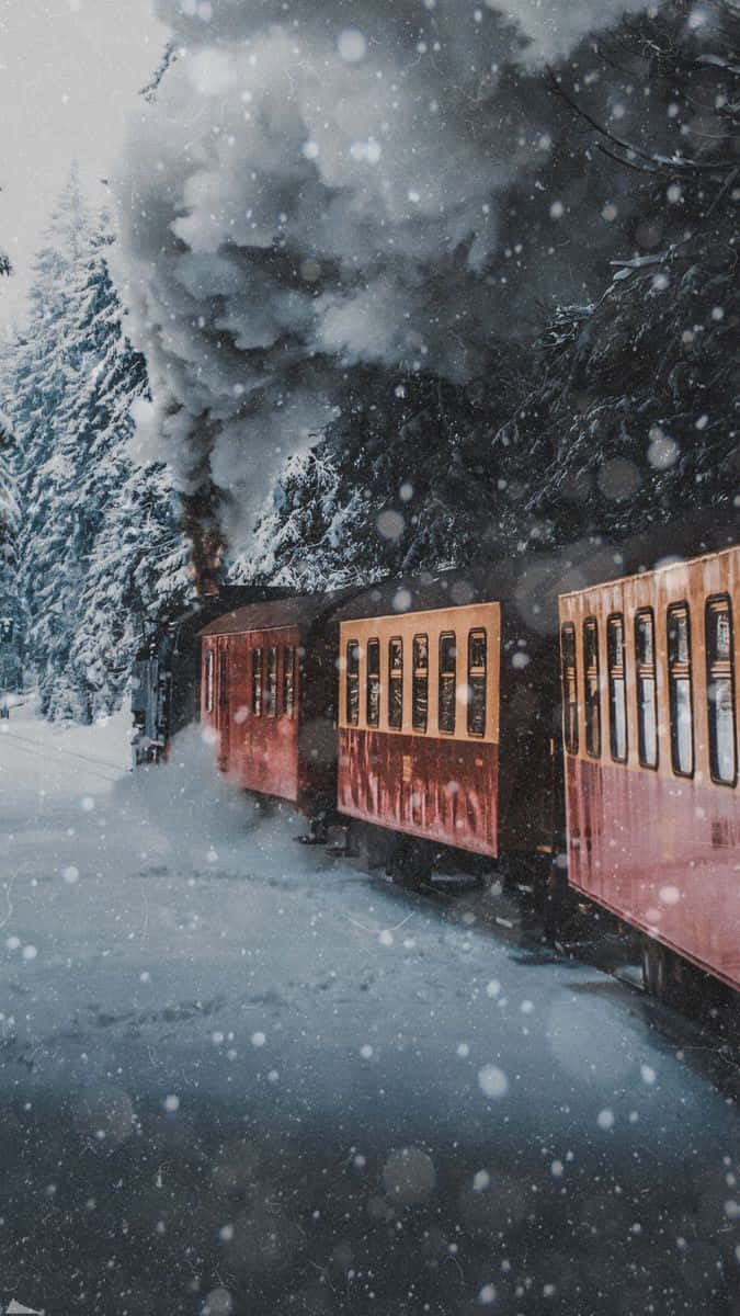 Winter Photography 桌布 壁紙 — 一輛復古紅色蒸汽火車穿過白雪覆蓋的森林，煙霧裊裊升起，雪花在周圍飄落。