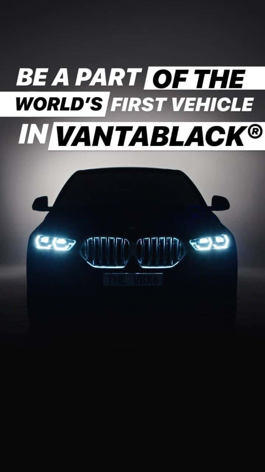 Vantablack 桌布 壁紙 — 一輛採用Vantablack塗裝的寶馬汽車，在黑暗的攝影棚背景下，明亮的車頭燈閃耀，並帶有粗體文字疊加。