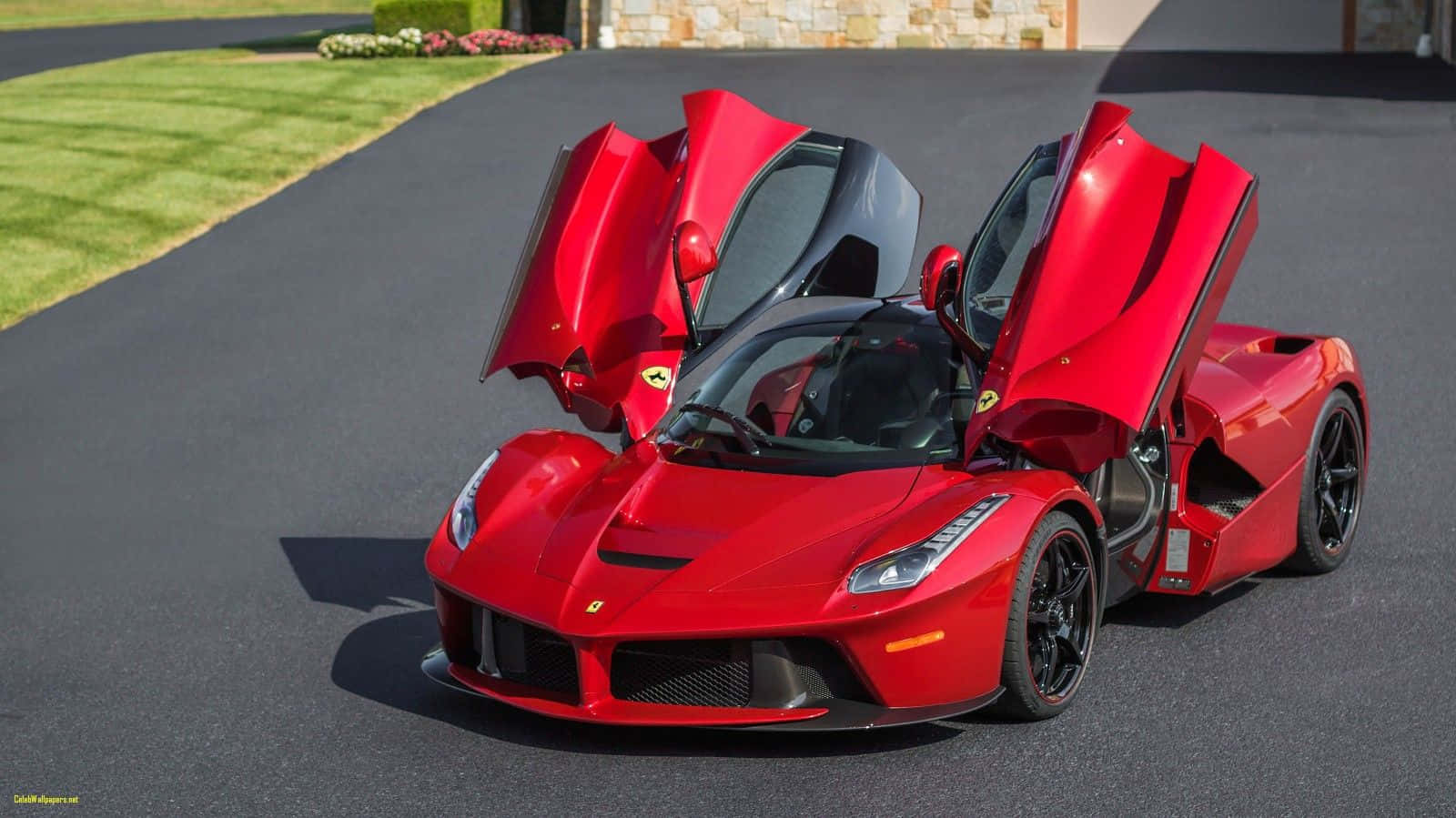 Ferrari Laferrari 桌布 壁紙 — 一輛搶眼的紅色法拉利 LaFerrari 打開鷗翼車門，停在鋪砌的車道上，旁邊是修剪整齊的綠色草坪和石牆。