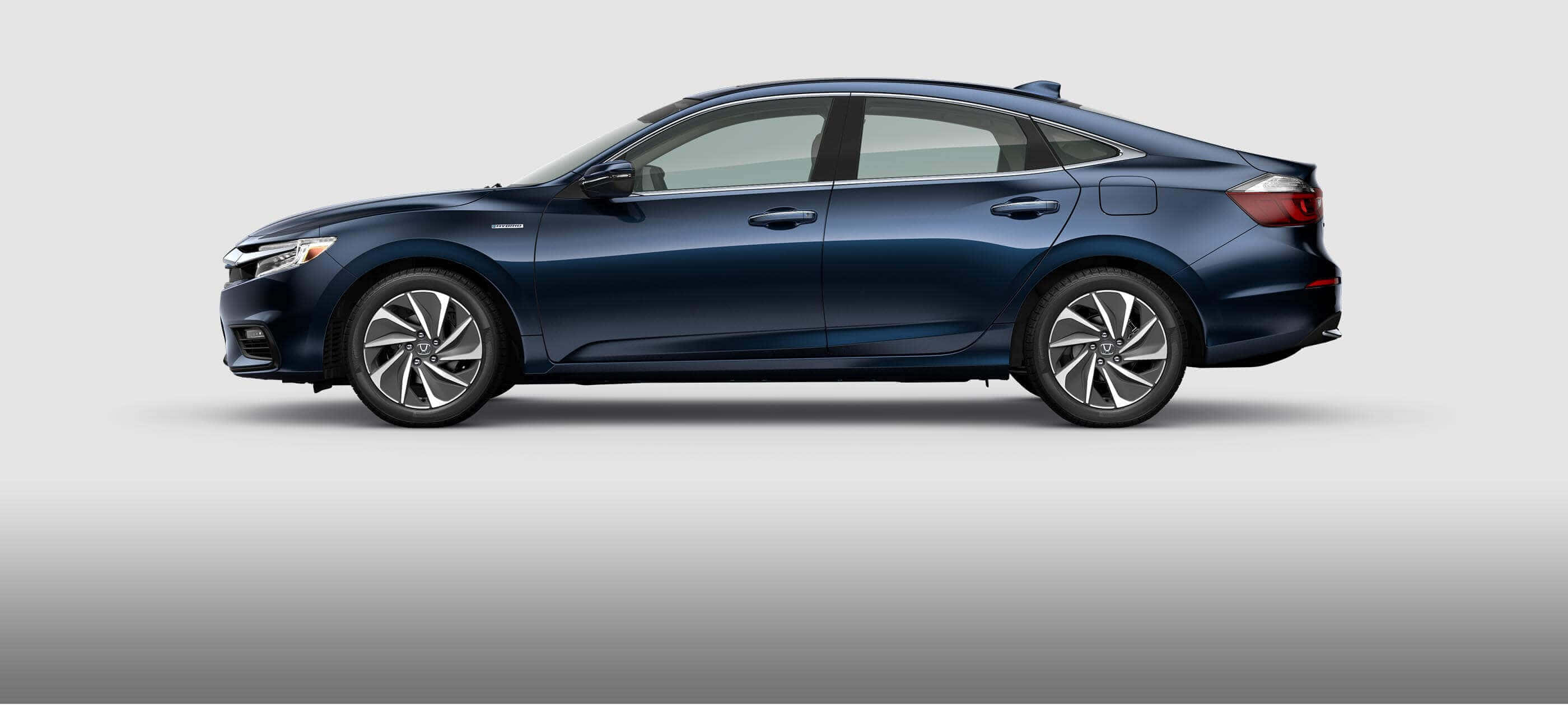 Honda Insight 桌布 壁紙 — 一輛時尚深藍色轎車以側面輪廓展示在純灰色工作室背景前。
