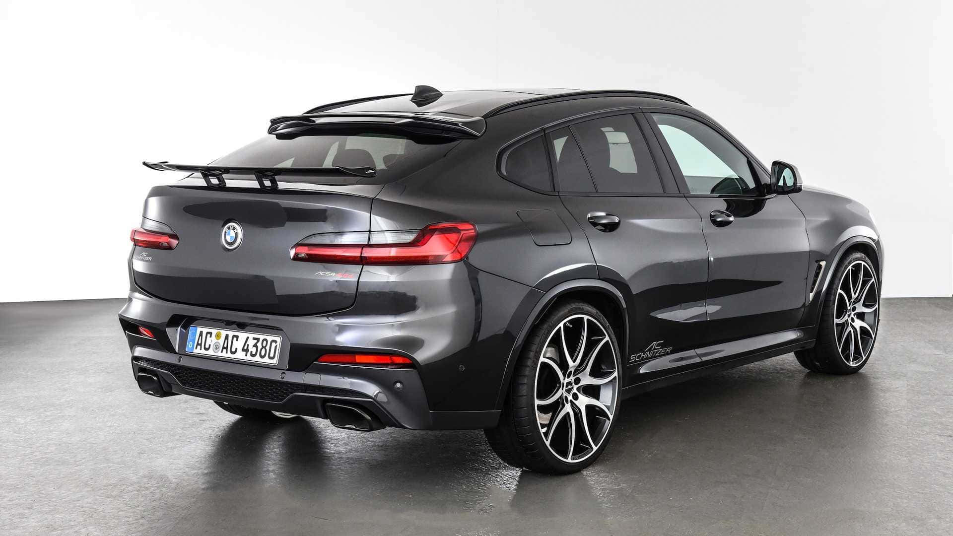 Bmw X4 桌布 壁紙 — 一輛時尚的啞光灰色BMW X6 M Competition SUV，帶有黑色飾件和定制輪圈，在極簡主義工作室環境中從後方四分之三角度拍攝。