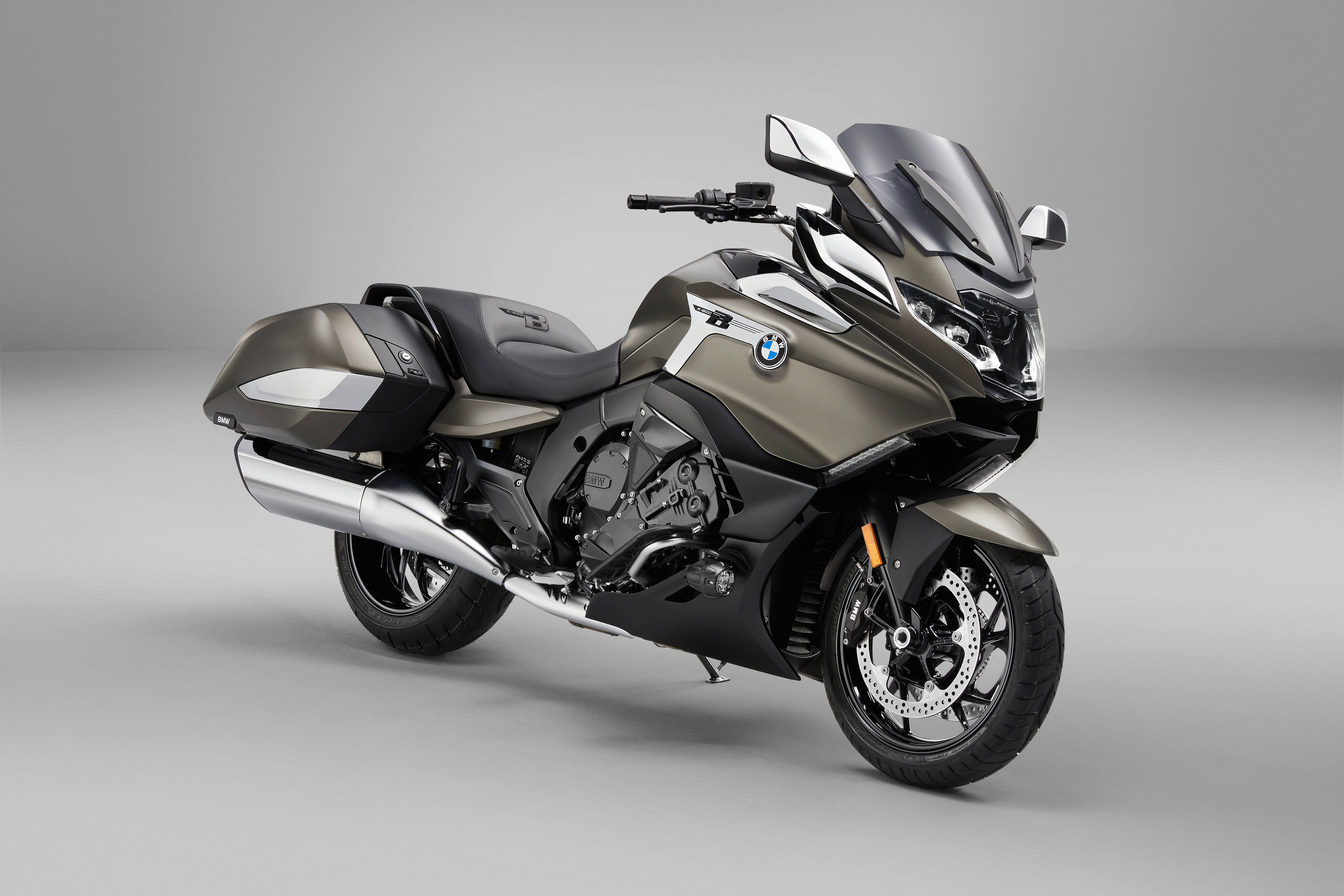 Bmw 桌布 壁紙 — 一輛時尚的啞光灰色BMW旅行摩托車，帶有鍍鉻裝飾和大擋風玻璃，擺放在極簡灰色工作室背景前。