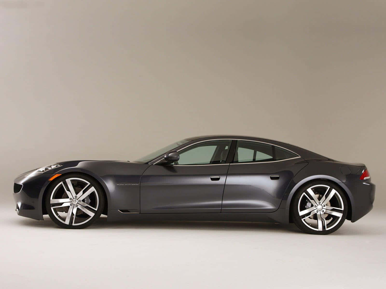 Fisker 桌布 壁紙 — 一輛時尚的啞光灰色跑車配備銀色合金輪圈，在中性工作室背景前以側面展示。
