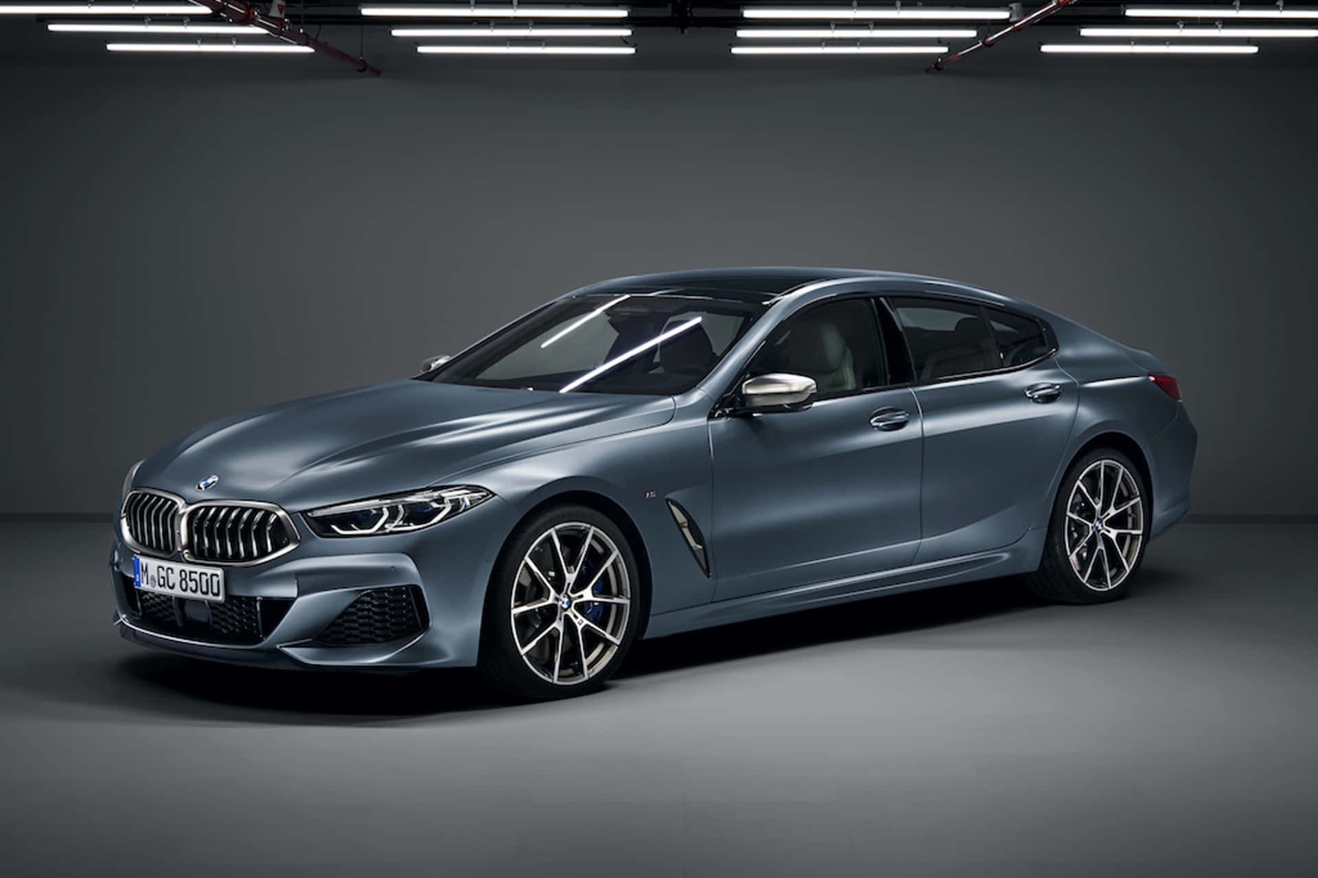 Bmw 8 Series 桌布 壁紙 — 一輛時尚的啞光藍色BMW 8系Gran Coupe在極簡灰色車庫的攝影棚燈光下閃耀。