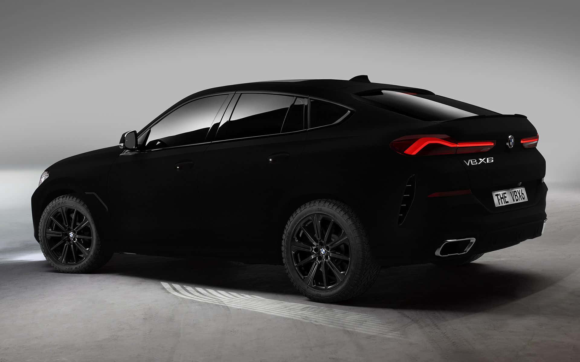 Vantablack 桌布 壁紙 — 一輛時尚的啞光黑色BMW X6，配以發光的紅色尾燈，在簡約的攝影棚環境中靜立。