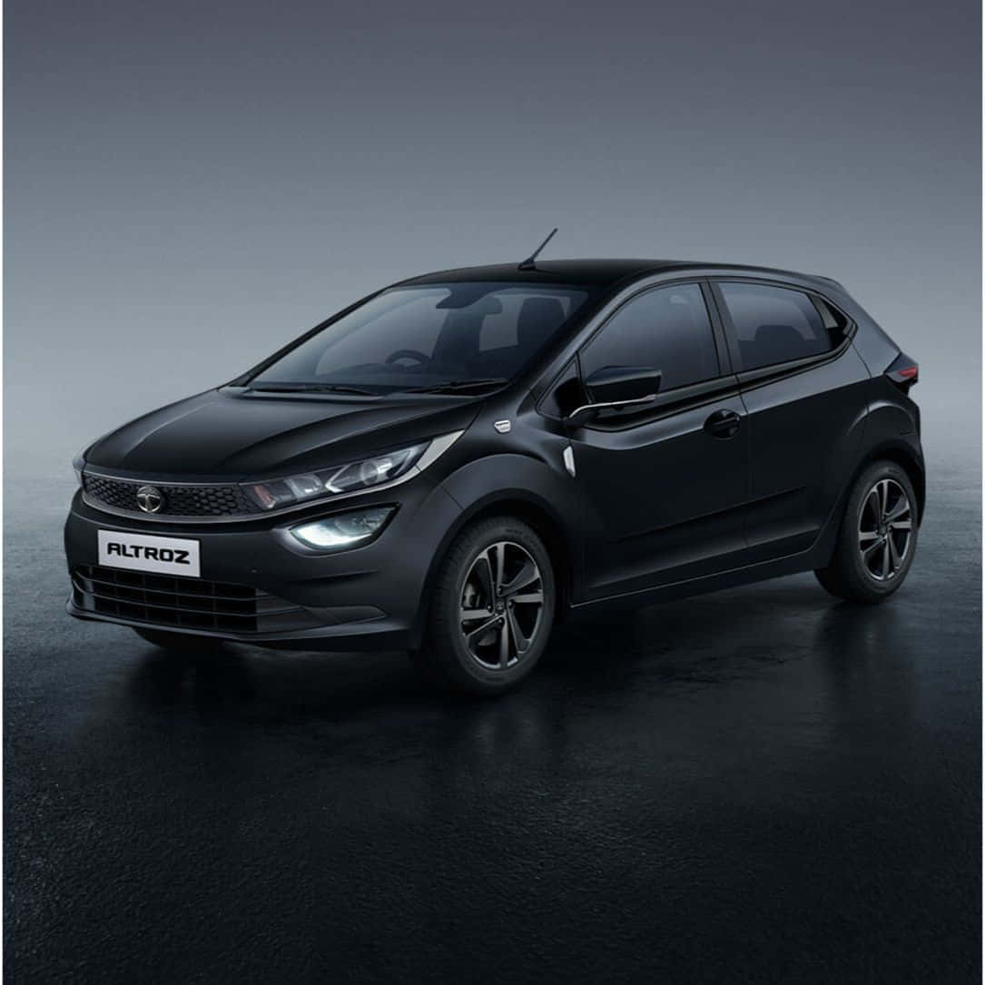 Tata Motors 桌布 壁紙 — 一輛時尚的啞光黑色Tata Altroz掀背車在攝影棚燈光下於深色反光表面閃耀。