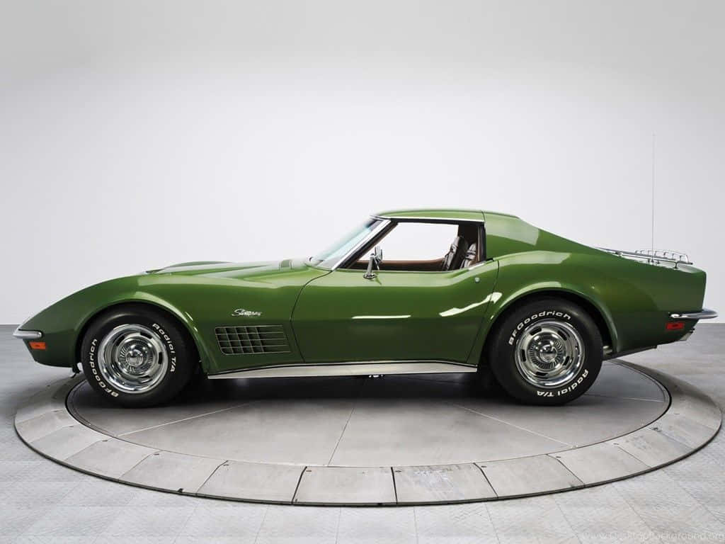 classic 桌布 壁紙 — 一輛時尚的復古綠色Corvette跑車在圓形轉盤上，在攝影棚燈光下閃閃發光。