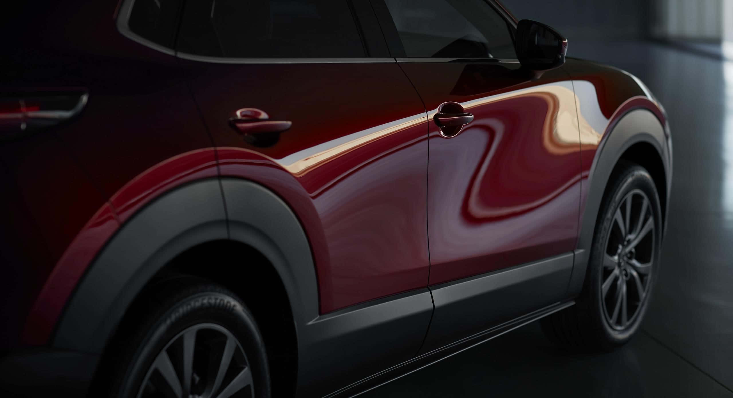 Mazda Cx-30 桌布 壁紙 — 一輛時尚的栗色SUV在攝影棚燈光下展示光澤曲線和黑色飾邊。