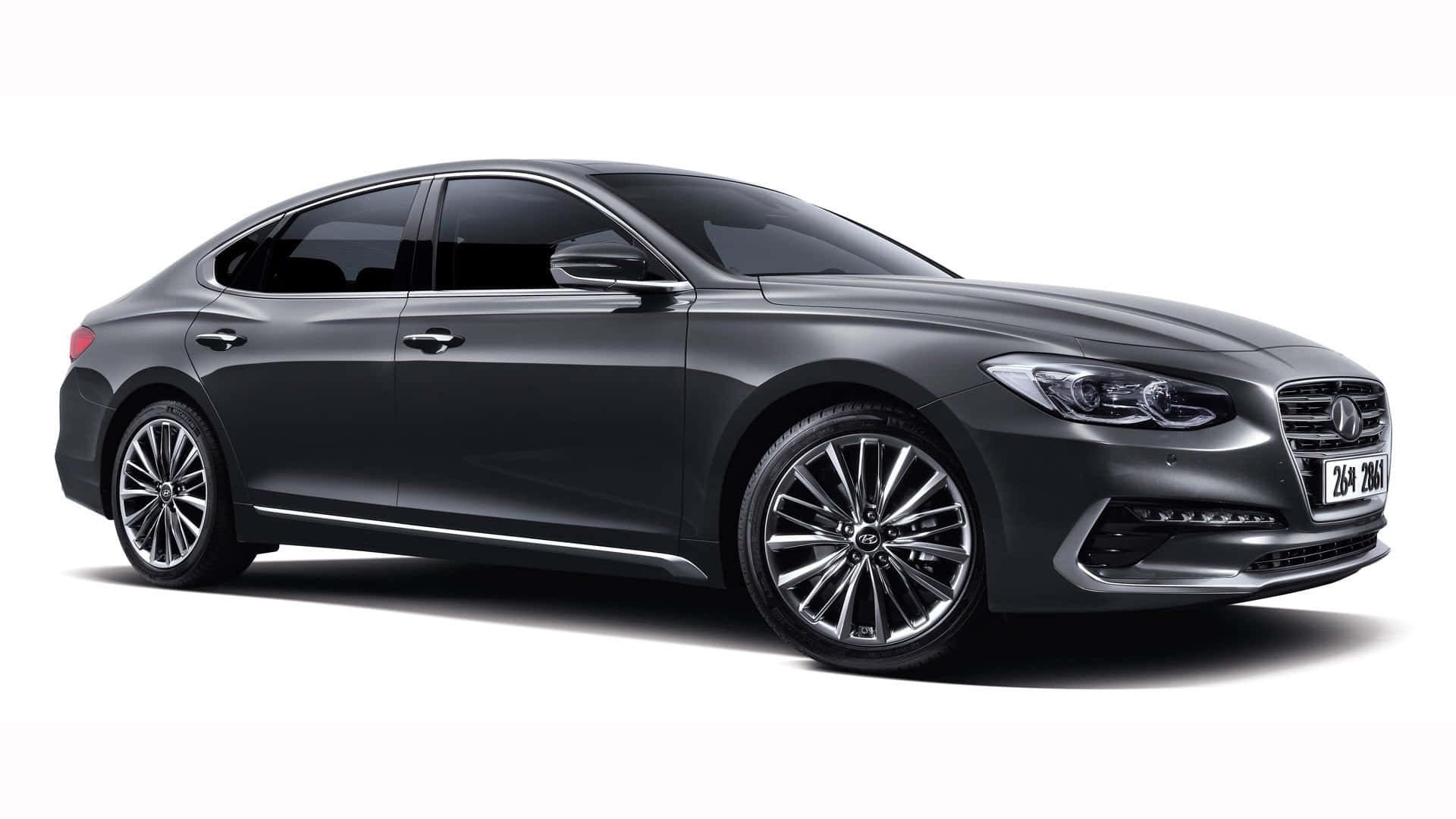 Hyundai Azera 桌布 壁紙 — 一輛時尚的深灰色豪華轎車，帶有鍍鉻裝飾和合金輪圈，在白色背景的影樓燈光下展示。