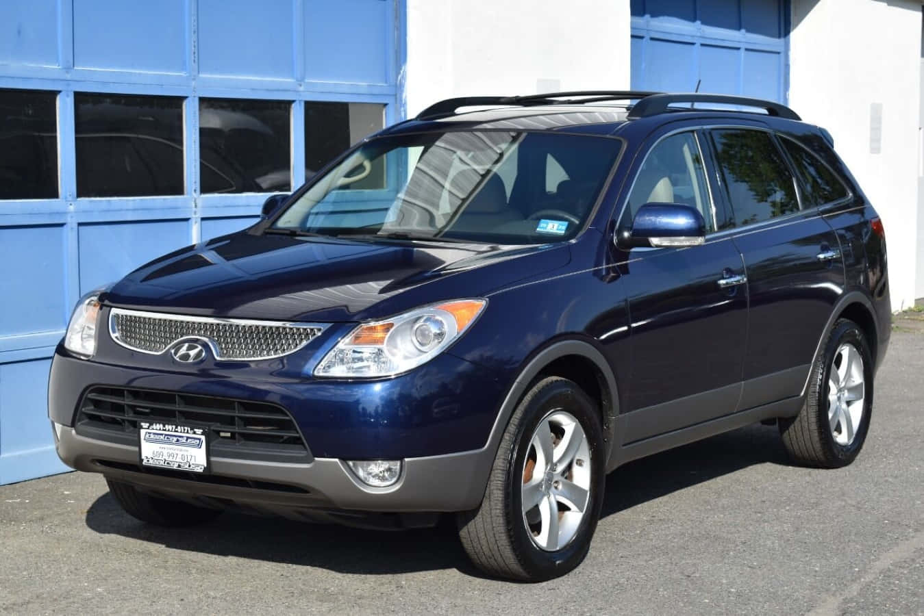 Hyundai Veracruz 桌布 壁紙 — 一輛時尚的深藍色現代Santa Fe SUV停放在一個陽光明媚的日子裡，藍色車庫門前。