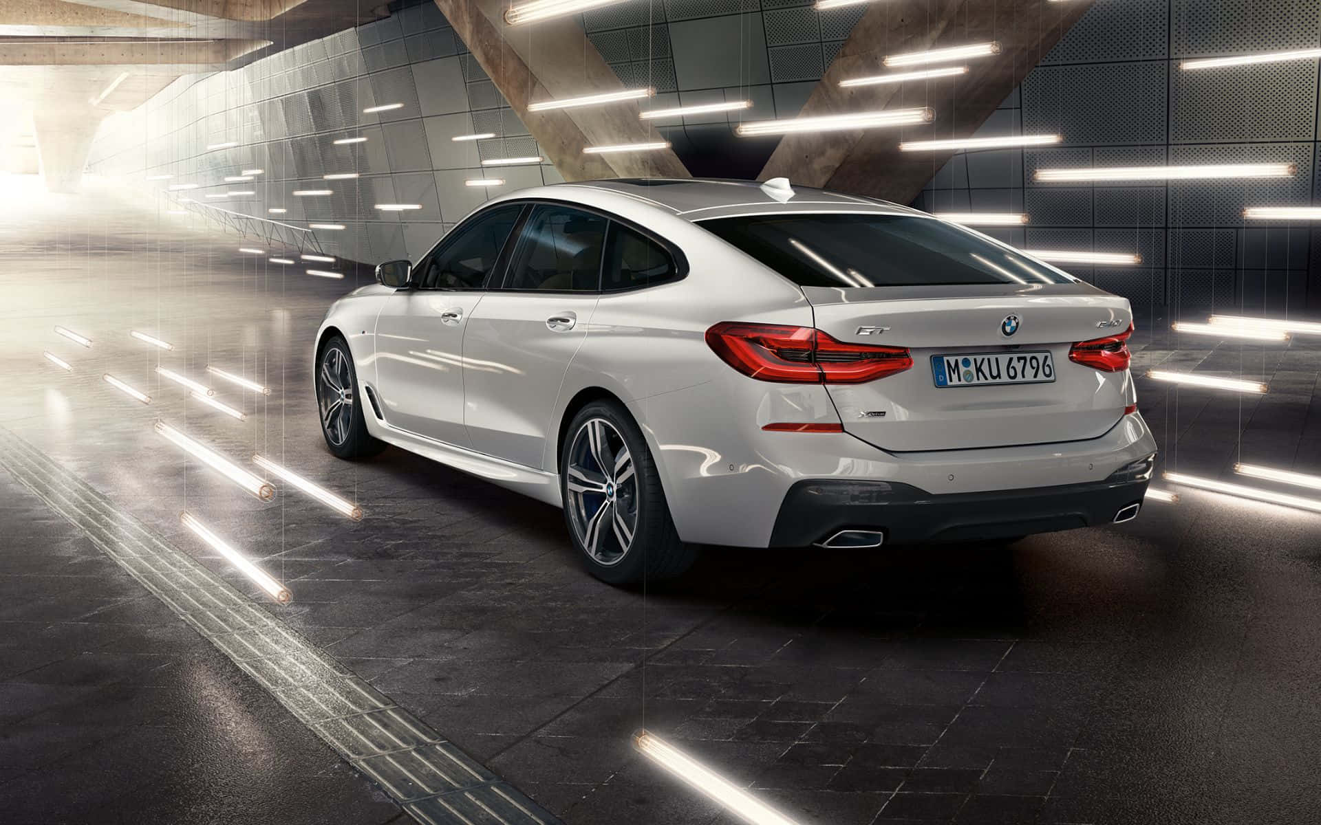 Bmw 6 Series 桌布 壁紙 — 一輛時尚的白色BMW Gran Coupe在現代隧道中滑行，隧道由條狀線性燈光照明。