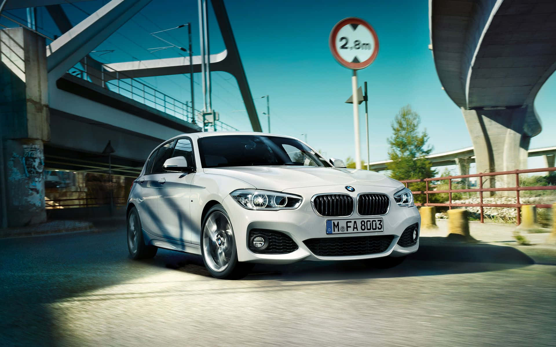 Bmw 1 Series 桌布 壁紙 — 一輛時尚的白色BMW房車在晴朗的日子裡行駛在現代混凝土天橋下。