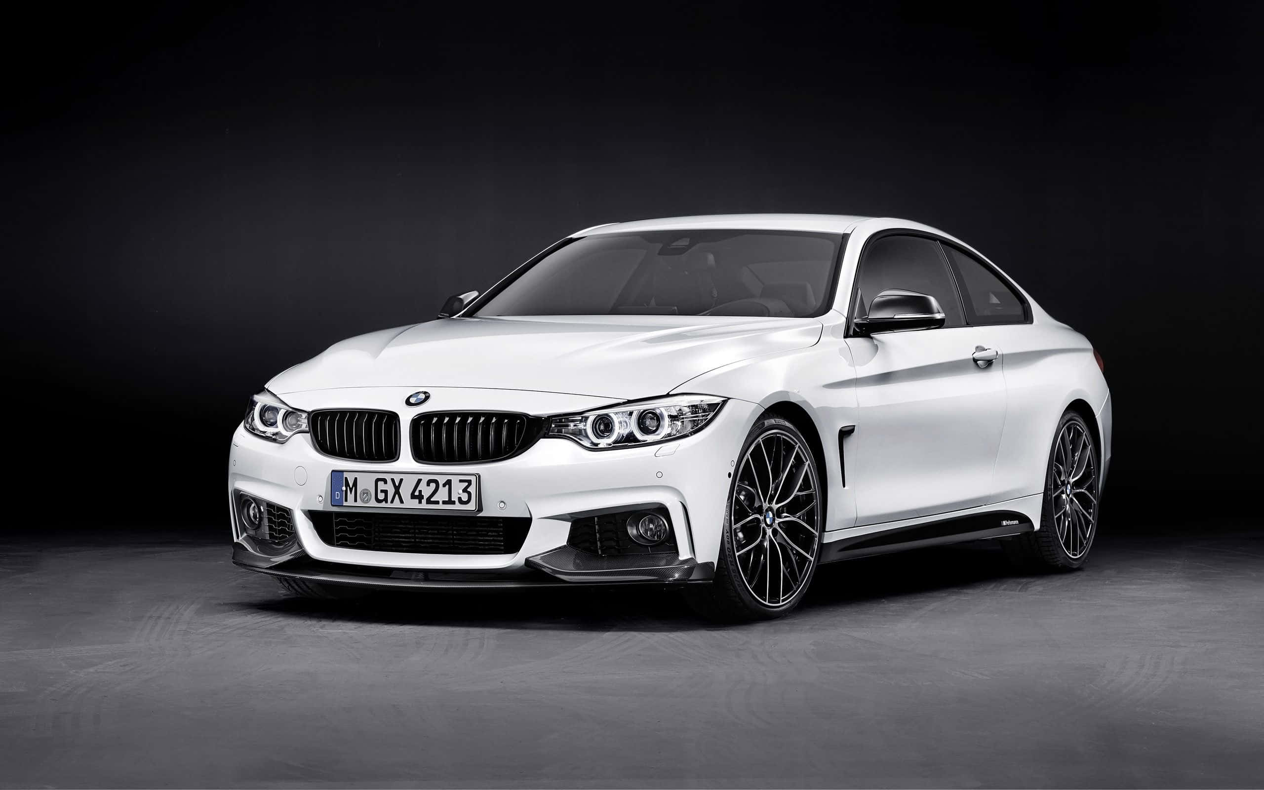 Bmw 4 Series 桌布 壁紙 — 一輛時尚的白色BMW雙門轎跑車在攝影棚燈光下閃閃發光，以深色背景襯托出其運動化設計和黑色合金輪圈。