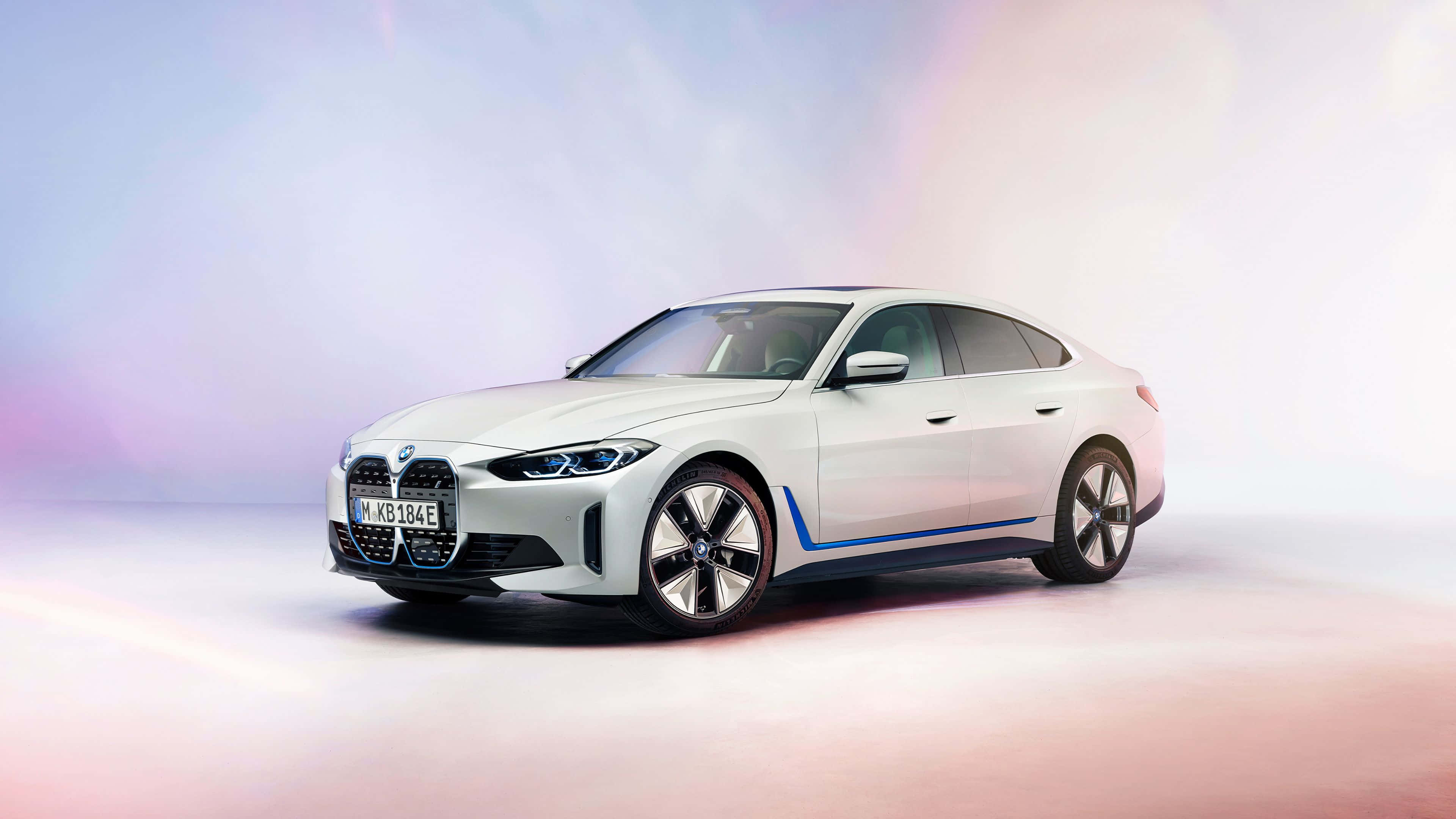 4K BMW 壁紙 桌布 壁紙 — 一輛時尚的白色BMW電動車帶有藍色點綴，在工作室柔和粉彩燈光下閃耀。