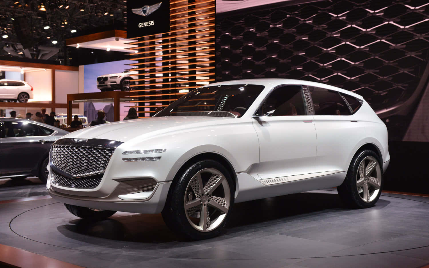 Genesis Gv80 桌布 壁紙 — 一輛時尚的白色Genesis概念SUV在車展的圓形平台上，在明亮的展覽燈光下閃閃發光。