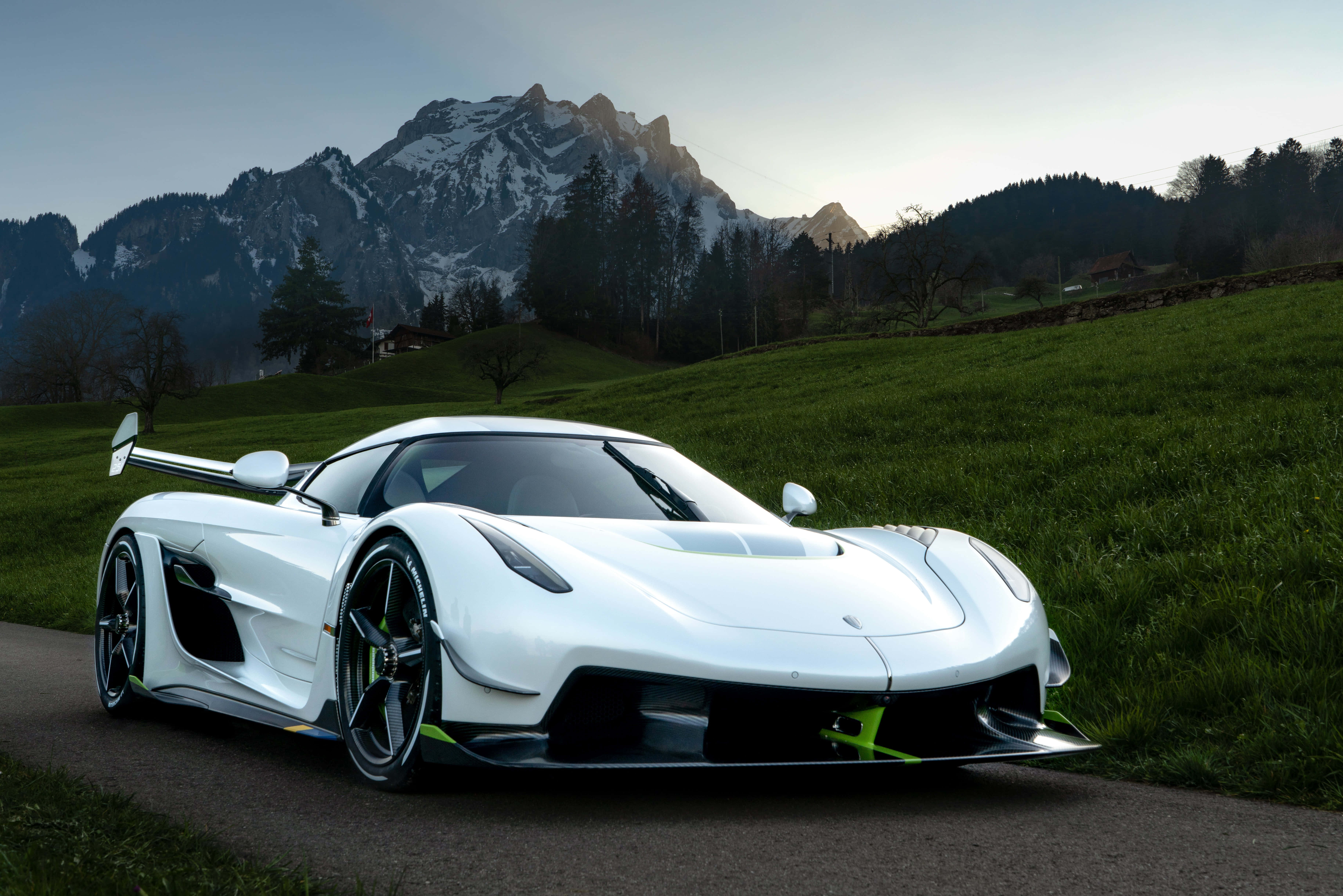 Sports Car 桌布 壁紙 — 一輛時尚的白色Koenigsegg超跑停在蜿蜒的道路上，背景是黃昏時分積雪的山峰和綠色的山丘。