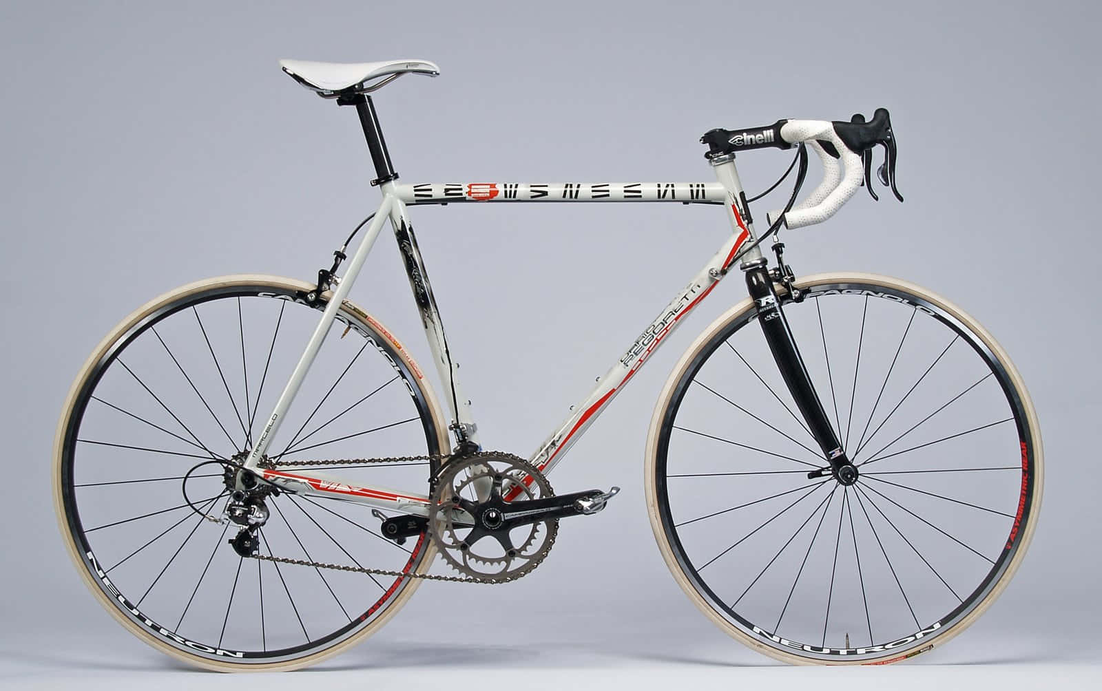Bicycle 桌布 壁紙 — 一輛時尚的白色和紅色公路自行車，配以奶油色輪胎，在灰色中性攝影棚背景下蓄勢待發。