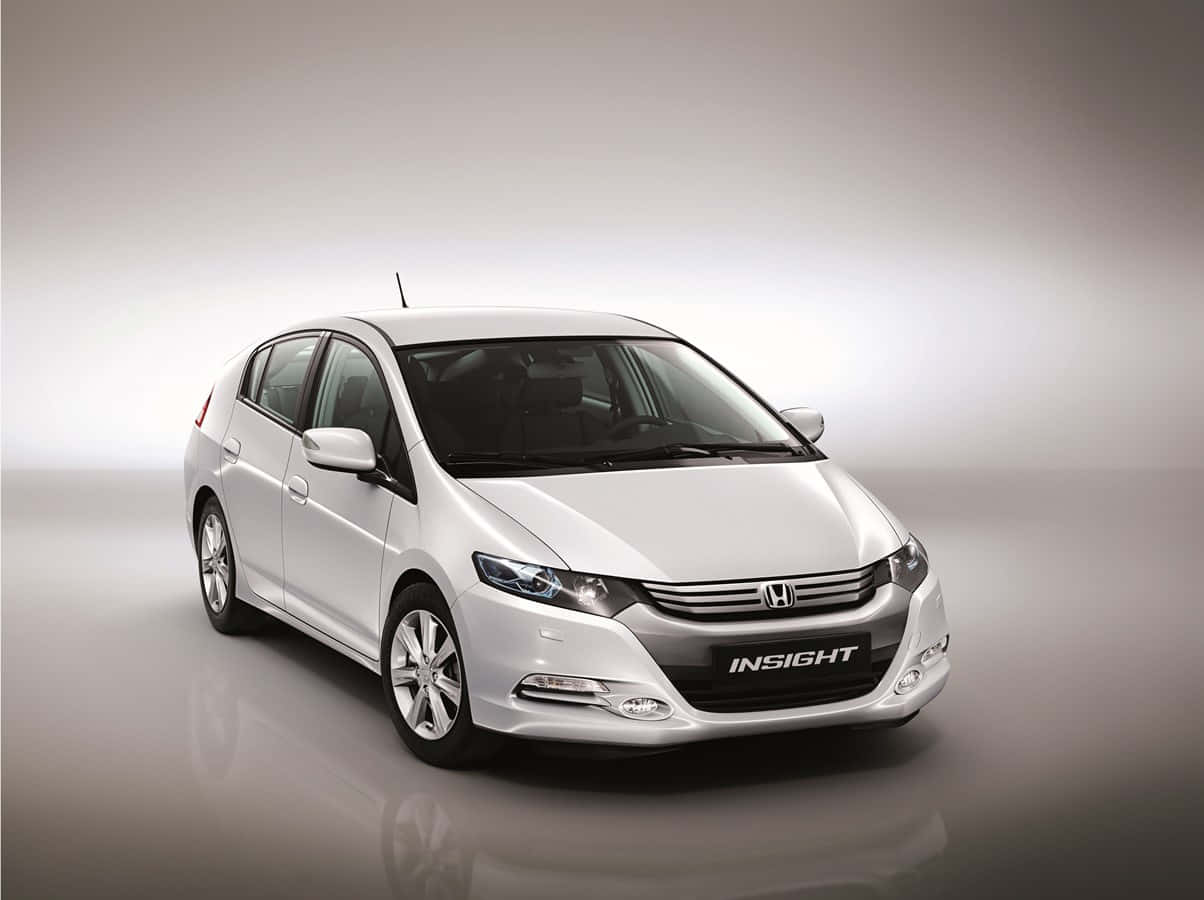 Honda Insight 桌布 壁紙 — 一輛時尚的白色本田Insight混合動力車在簡約的工作室中展示，配有柔和燈光和反光地板。