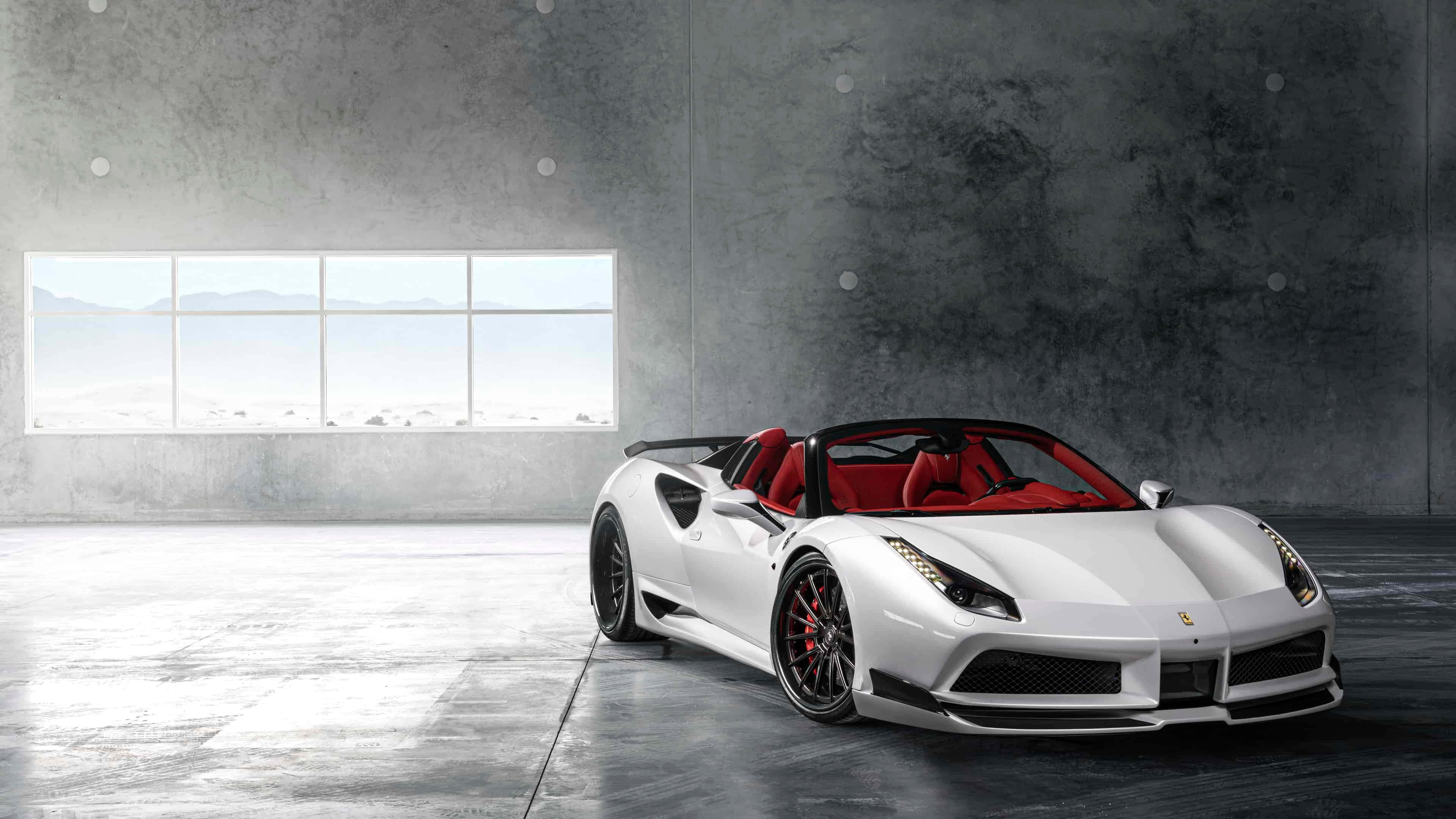 Ferrari 488 Spider 桌布 壁紙 — 一輛時尚的白色法拉利敞篷車，紅色內飾，停放在簡約的混凝土車庫中，透過大窗戶可欣賞山景。