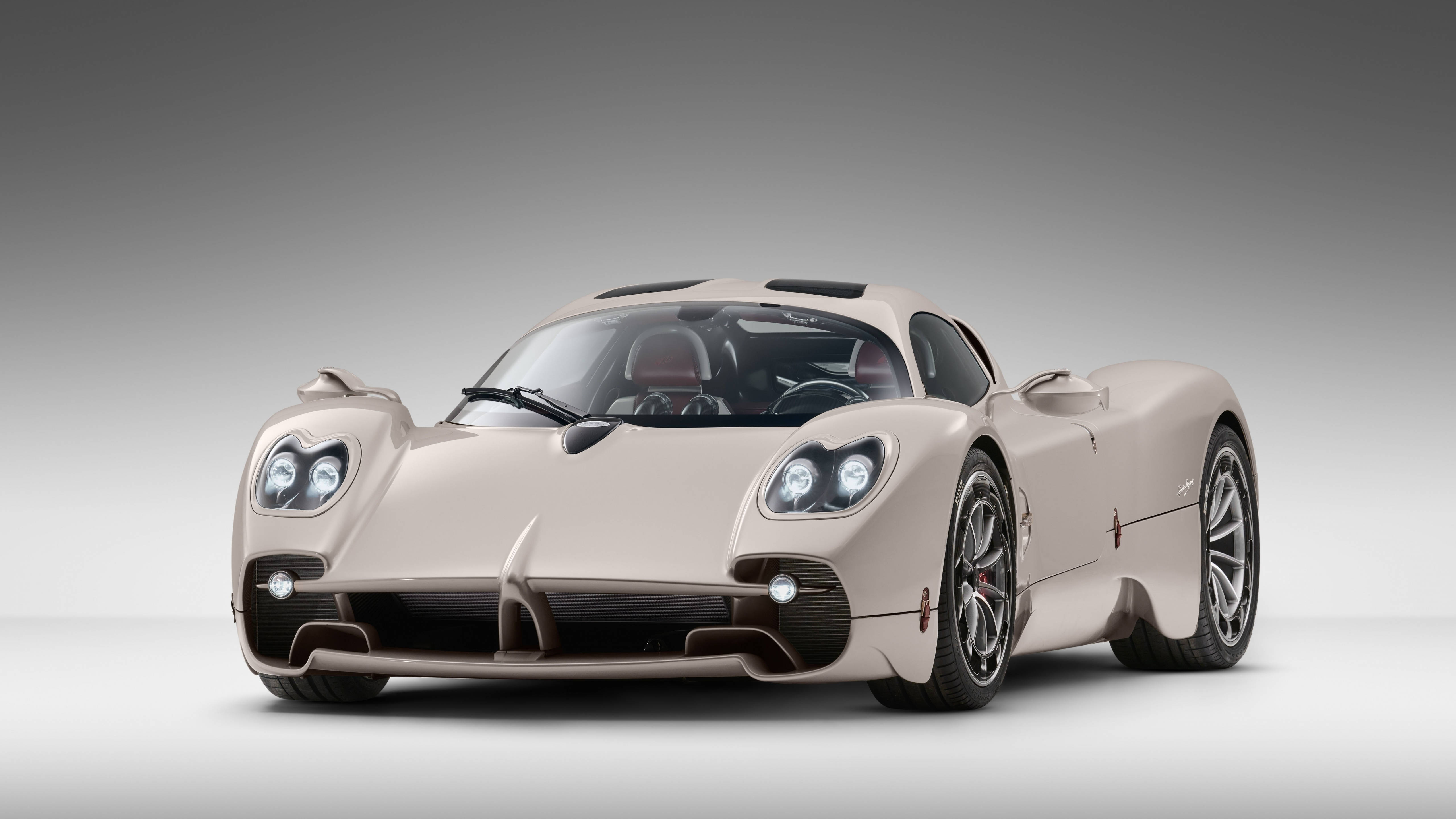 Racing Car 桌布 壁紙 — 一輛時尚的米色Pagani Zonda跑車，帶有發光的車頭燈和黑色飾邊，在漸變灰色工作室背景前擺姿勢。