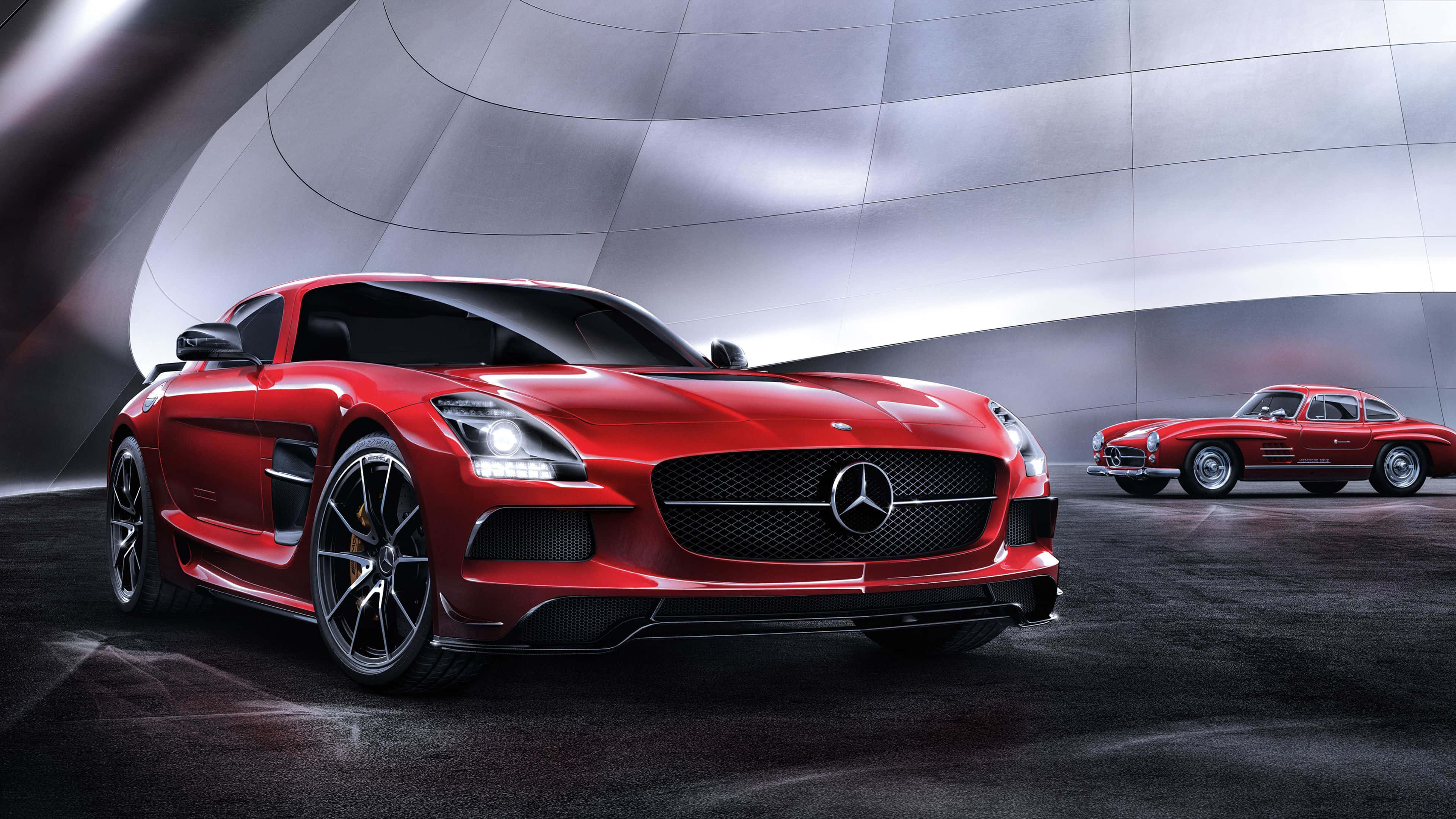 4K Mercedes 桌布 壁紙 — 一輛時尚的紅色 Mercedes SLS AMG 跑車在攝影棚燈光下閃閃發光，旁邊是一輛經典的紅色 Mercedes 300SL Gullwing。