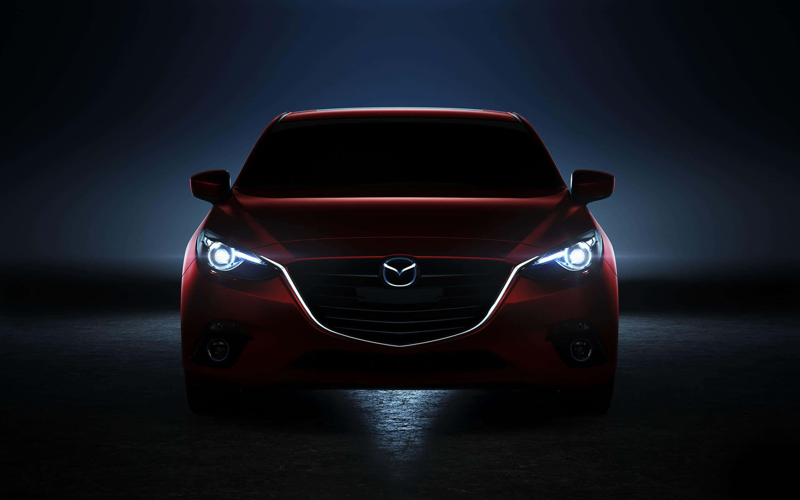 Mazda 6 桌布 壁紙 — 一輛時尚的紅色Mazda汽車在黑暗的攝影棚背景下發出明亮的車頭燈光芒。