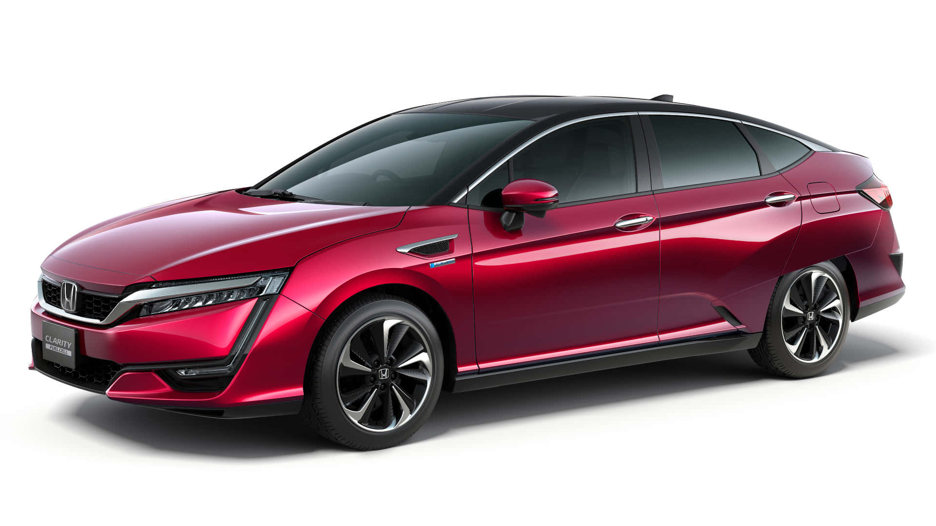 Honda Clarity 桌布 壁紙 — 一輛時尚的紅色本田Clarity插電式混合動力轎車，帶有黑色飾邊和現代頭燈，在工作室燈光下展示。
