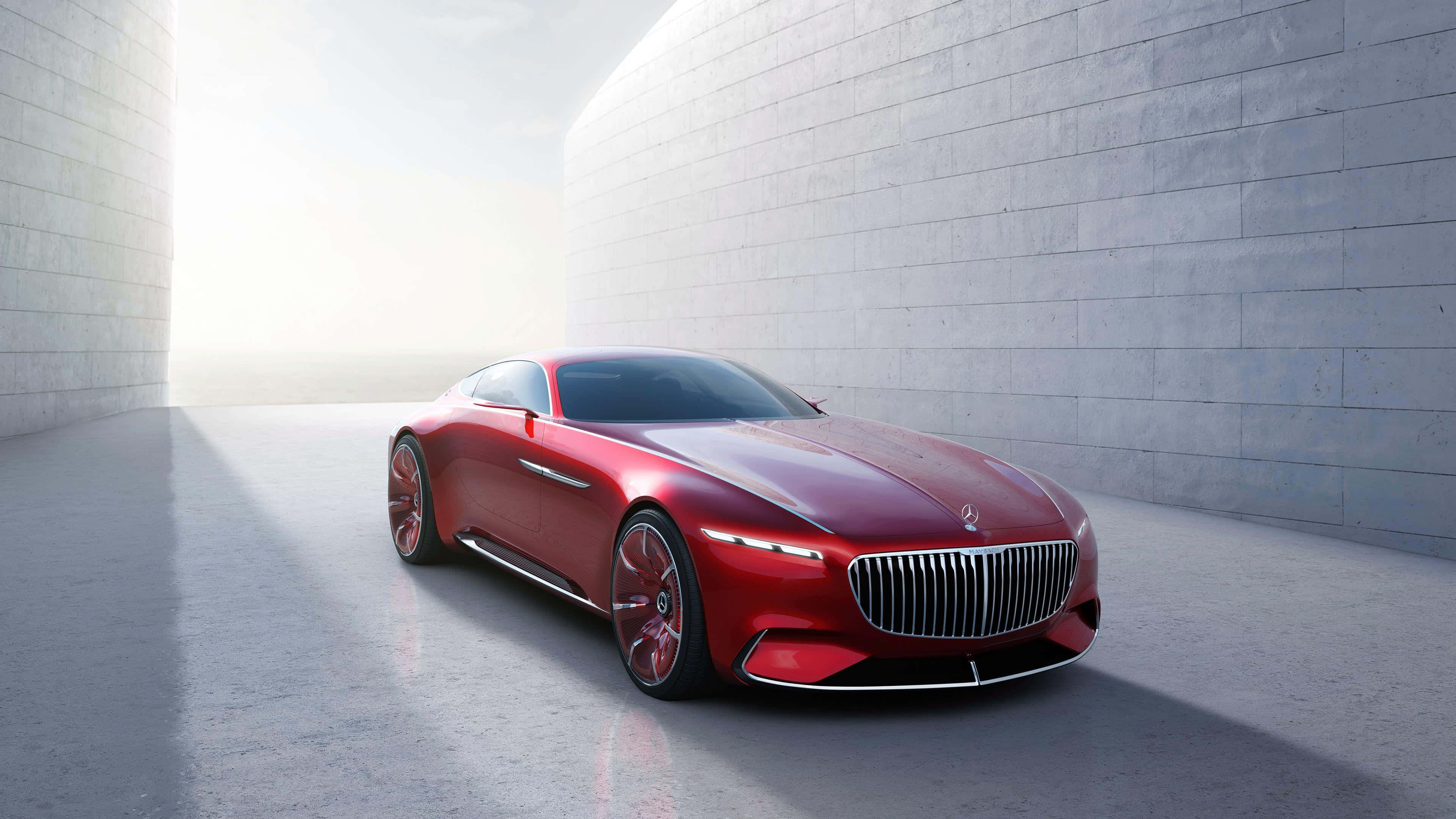 Maybach 桌布 壁紙 — 一輛時尚的紅色豪華跑車在柔和光線下，於極簡城市環境中高聳的混凝土牆之間閃耀。