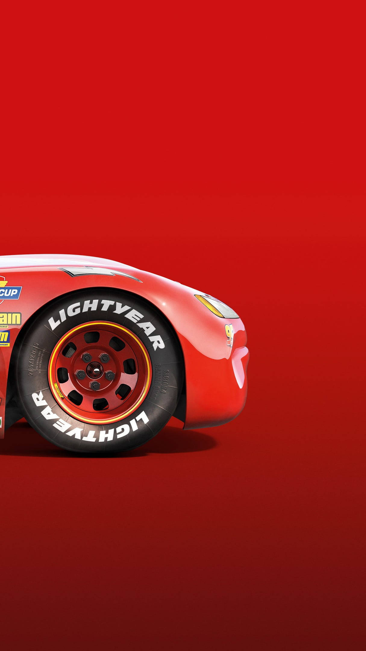 Disney Cars 桌布 壁紙 — 一輛時尚的紅色閃電麥坤賽車，配備「Lightyear」輪胎，傾斜在純紅色背景上。