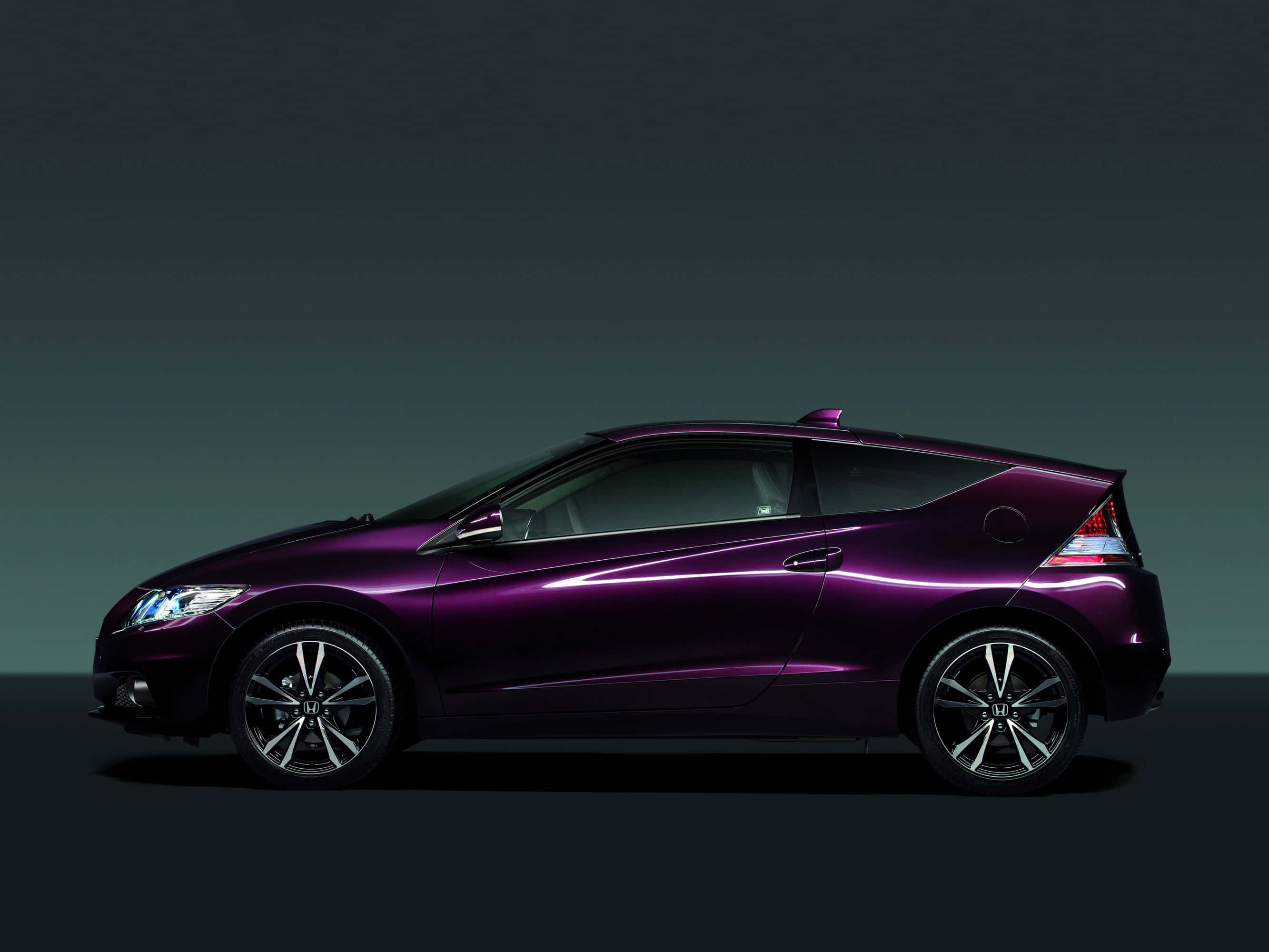 Honda Cr-z 桌布 壁紙 — 一輛時尚的紫色跑車在深色漸變工作室背景前以側面輪廓滑行，配以戲劇性燈光。