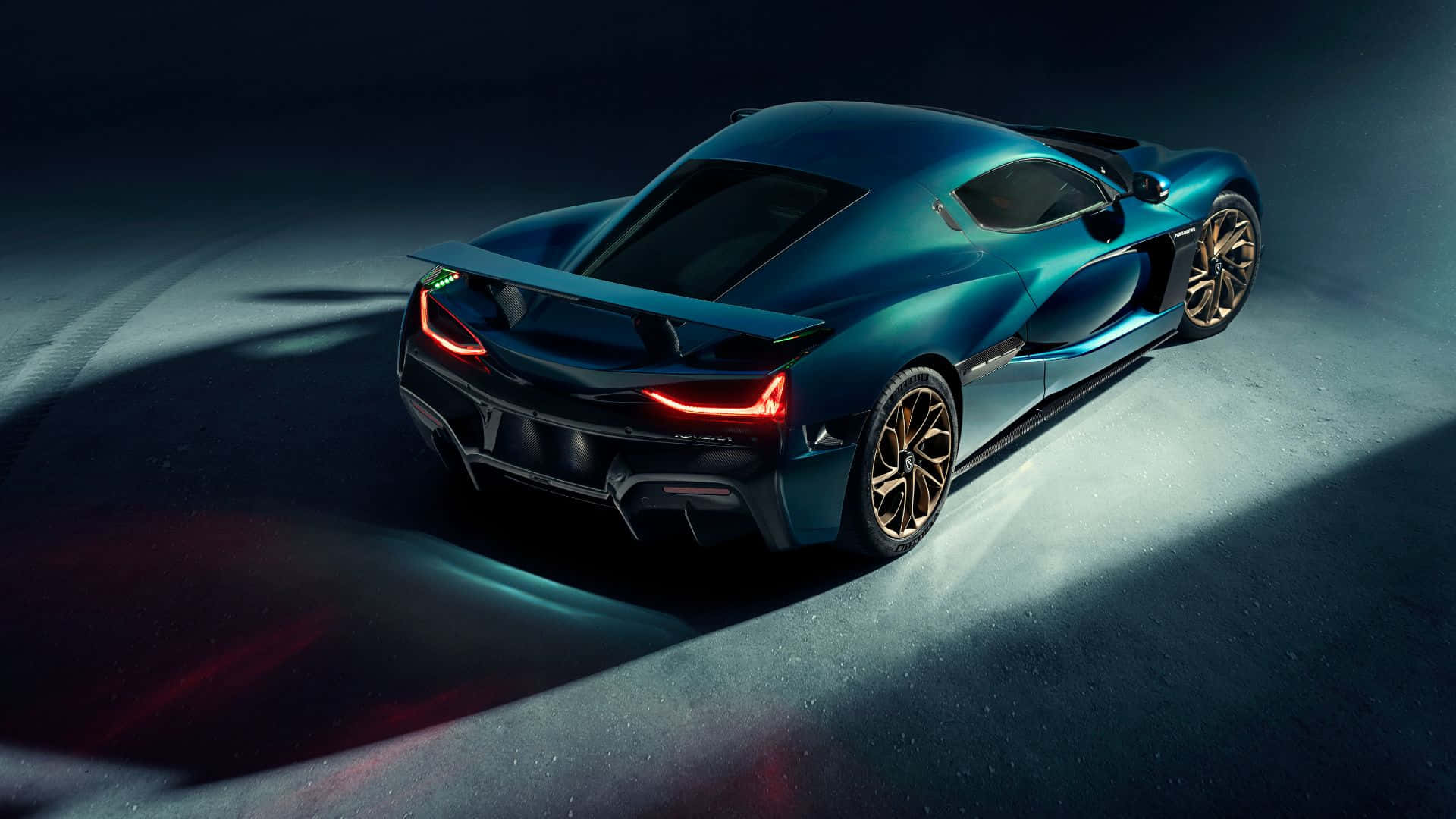 Rimac 桌布 壁紙 — 一輛時尚的藍綠色超跑在黑暗的攝影棚環境中，帶有發光的紅色尾燈，被戲劇性地照亮。