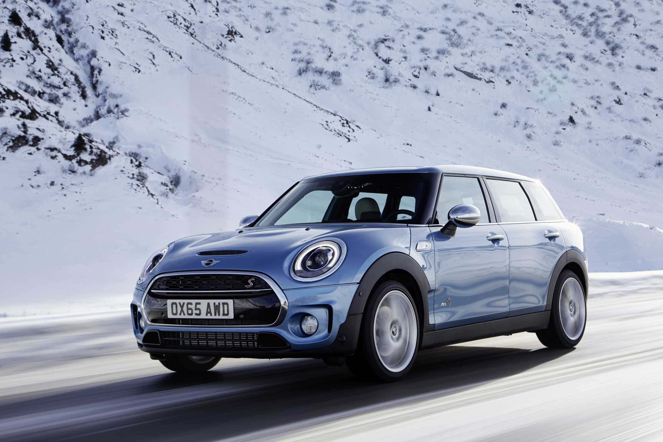 Mini Cooper S Clubman All4 桌布 壁紙 — 一輛時尚的藍色MINI Countryman在白雪覆蓋的山路上動態行駛，帶有模糊的動感效果。
