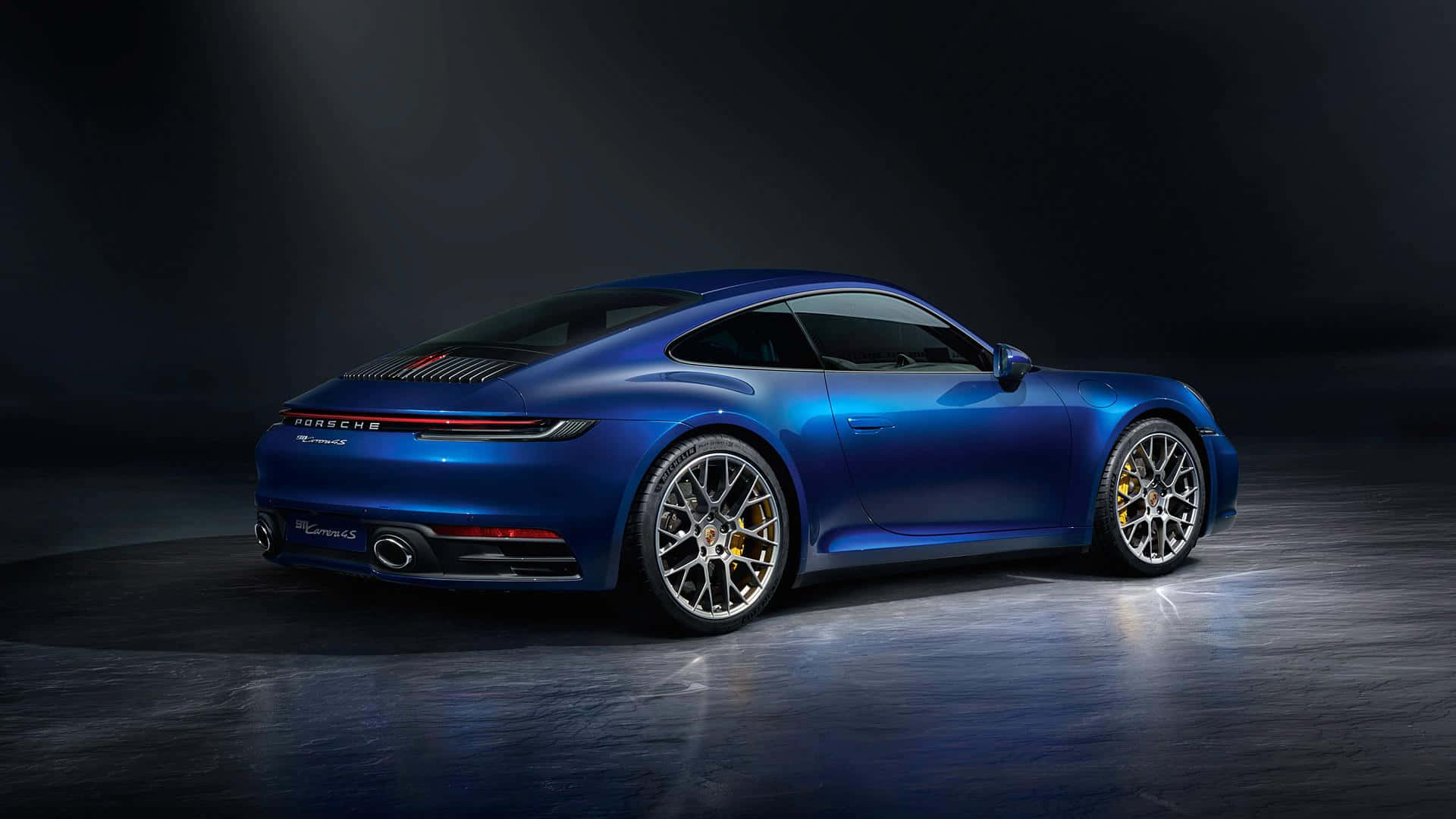 保時捷 桌布 壁紙 — 一輛時尚的藍色保時捷911 Turbo S在戲劇性的攝影棚燈光下，在黑暗背景中閃閃發光。
