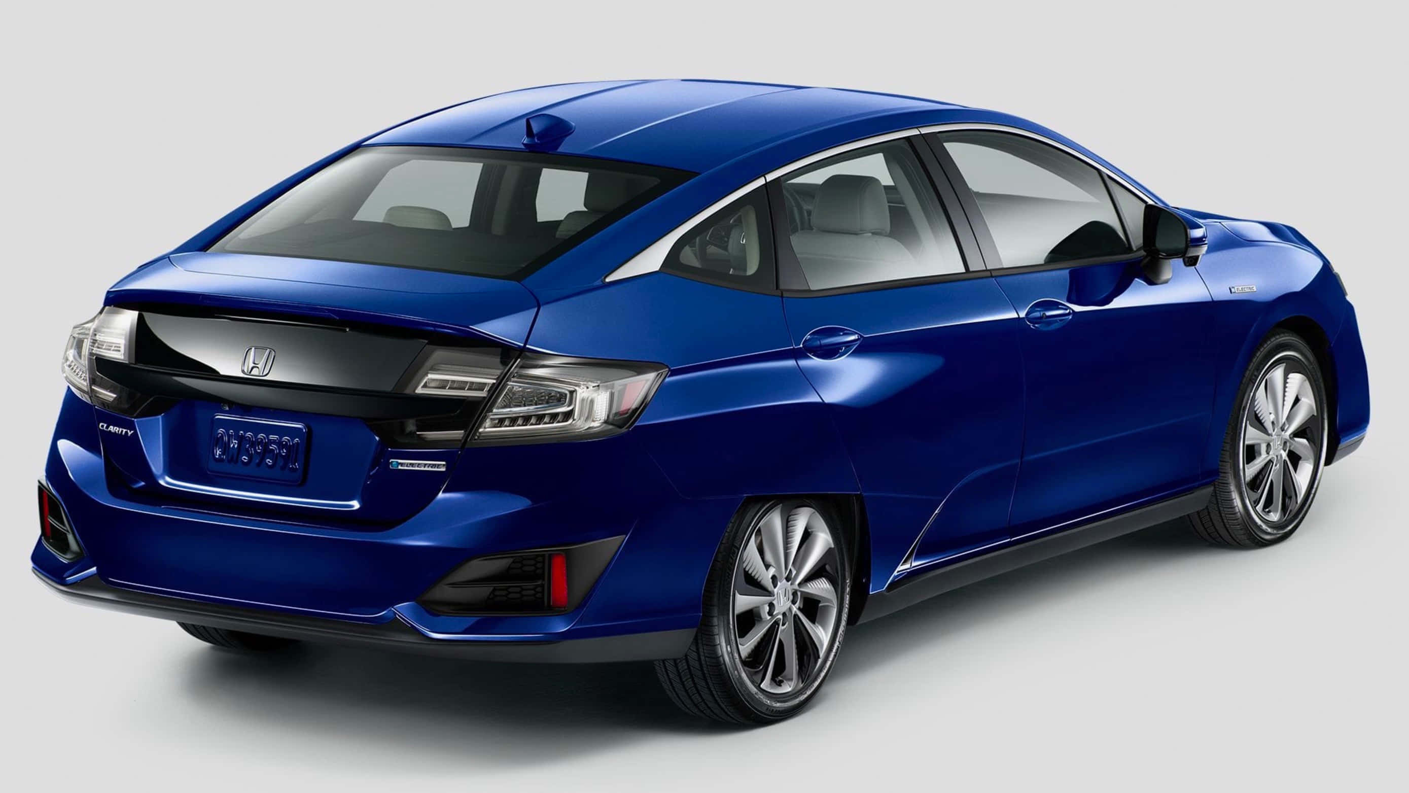 Honda Clarity 桌布 壁紙 — 一輛時尚的藍色本田Insight混合動力車在攝影棚燈光下從後方四分之三角度展示。