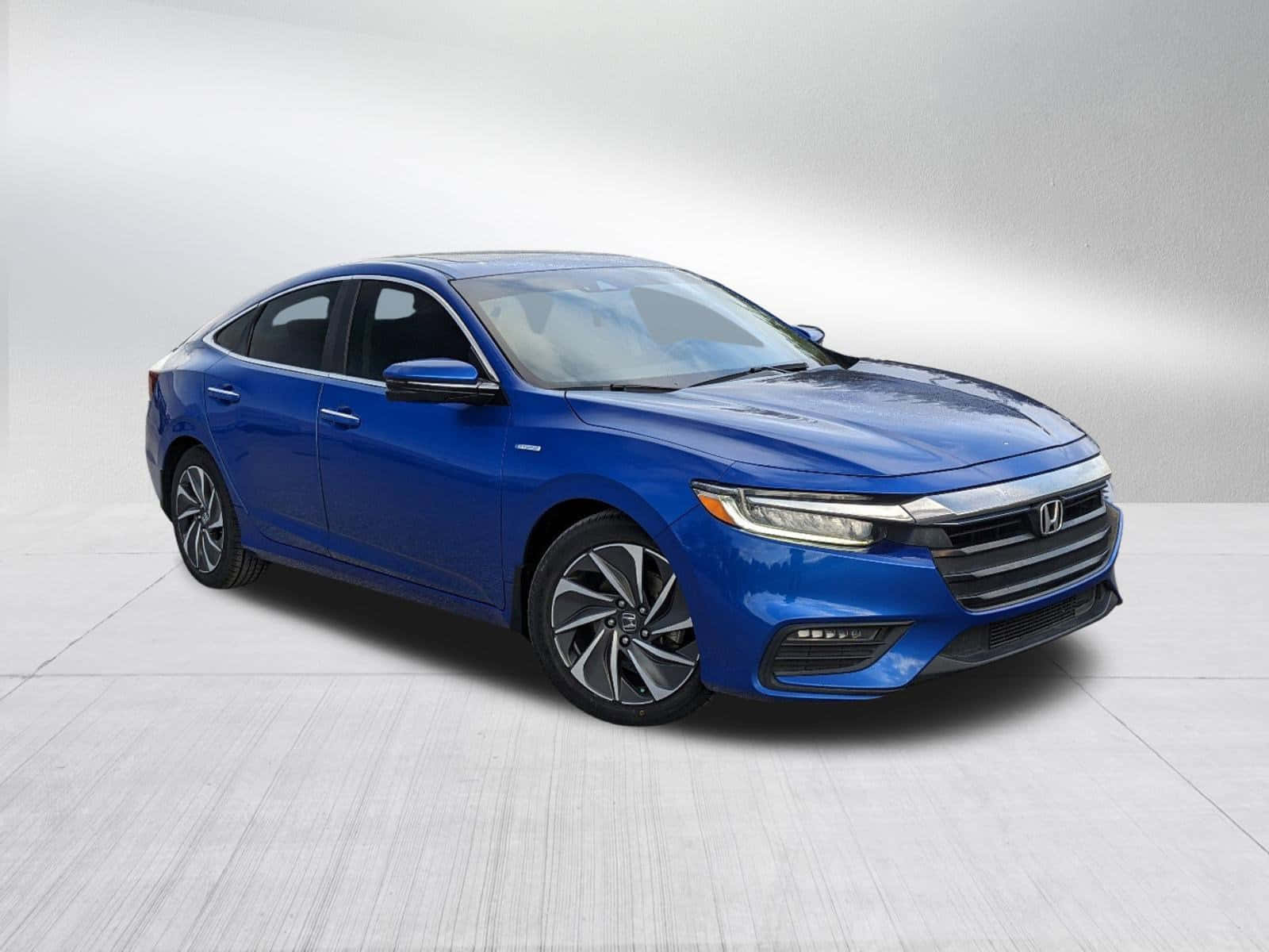 Honda Insight 桌布 壁紙 — 一輛時尚的藍色本田轎車在攝影棚燈光下閃耀，背景為簡約灰色。