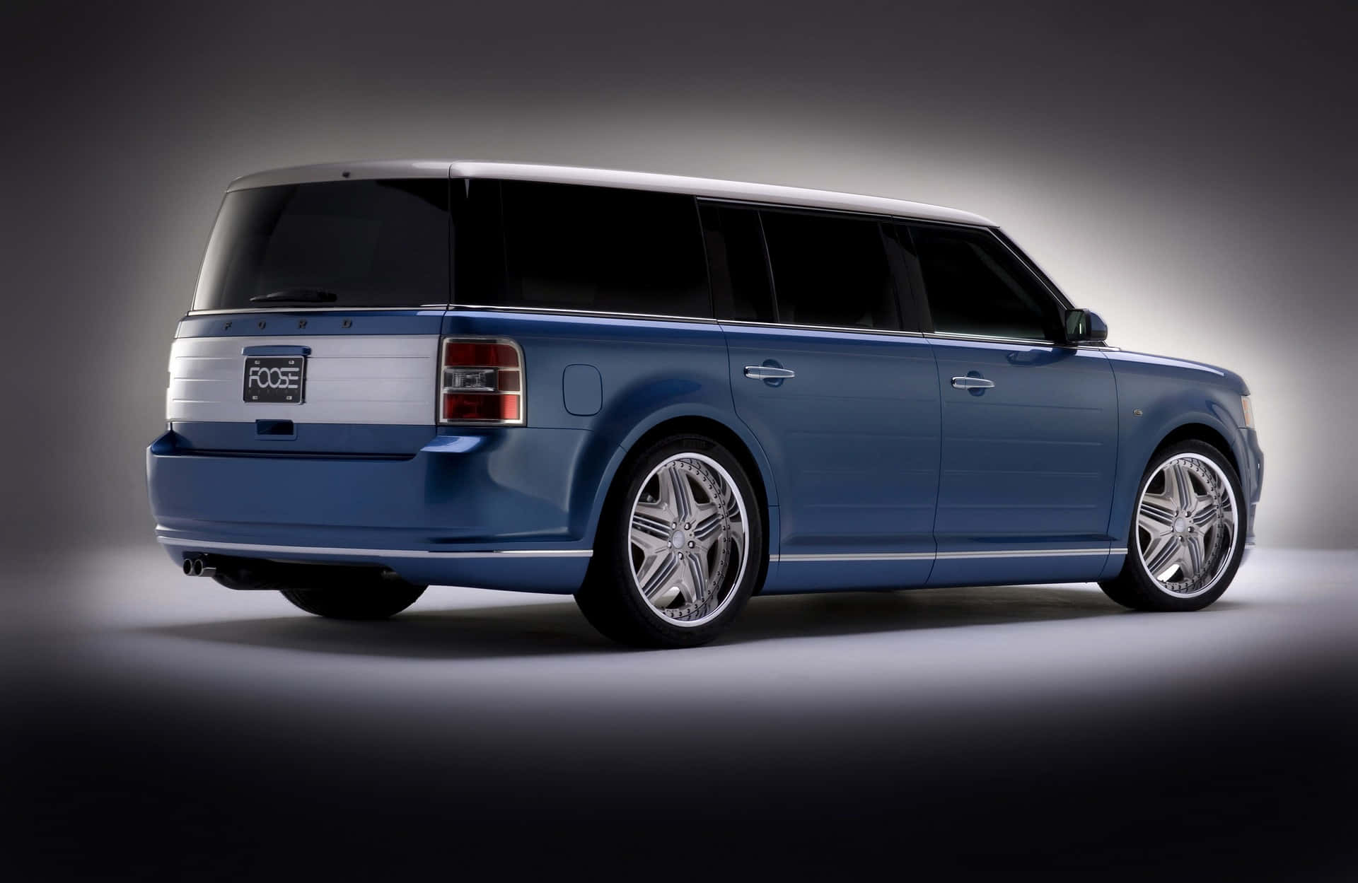 Ford Flex 桌布 壁紙 — 一輛時尚的藍色福特Flex配備定制鍍鉻輪圈，在工作室環境中以戲劇性燈光展示。