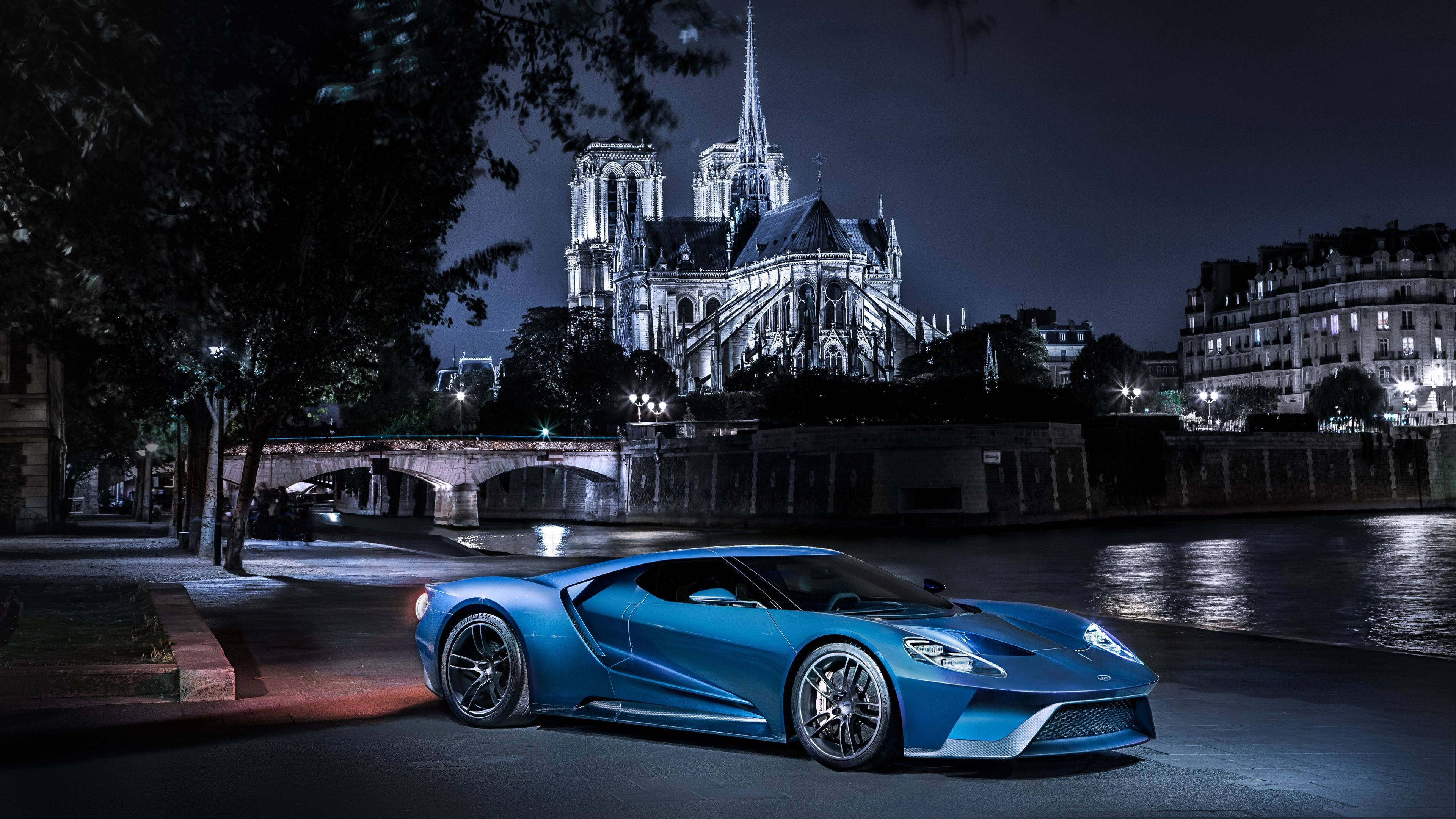 Ford 桌布 壁紙 — 一輛時尚的藍色跑車在塞納河畔的夜燈下閃耀，背景是燈火通明的聖母院。