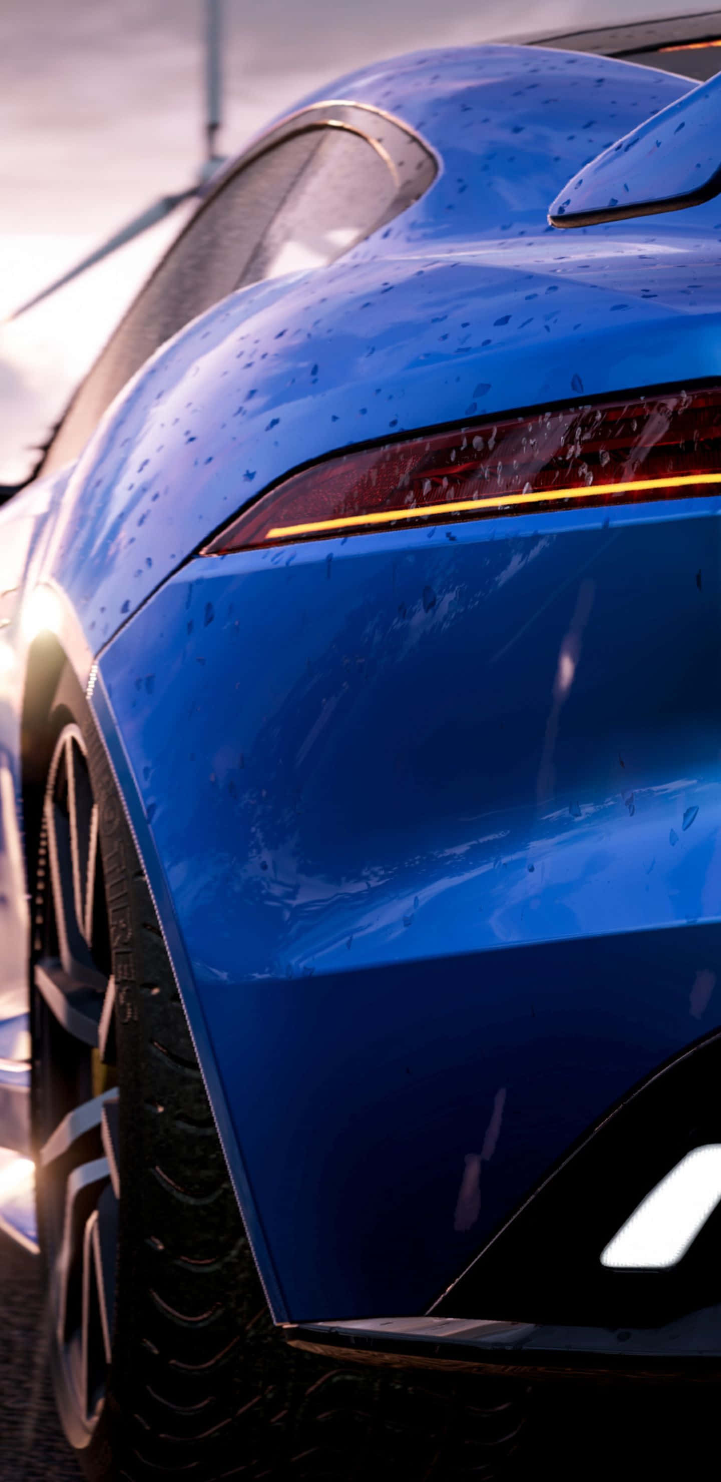 《Need for Speed Most Wanted》 壁紙 — 一輛時尚的藍色跑車在金色夕陽下閃爍著雨滴，凸顯其彎曲的車尾和發光的尾燈。